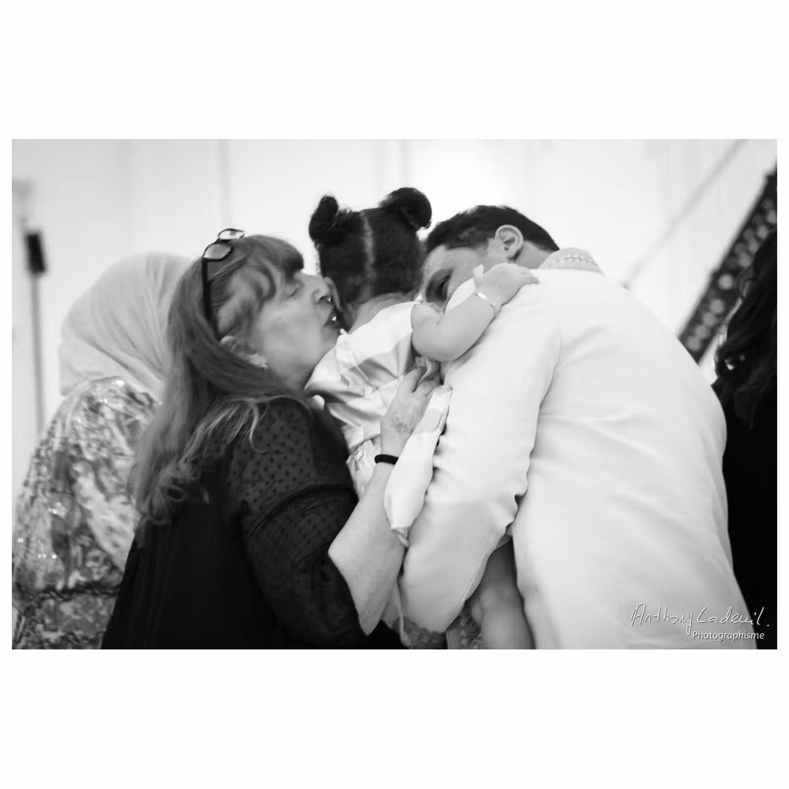 Photographie noir et blanc de deux personnes embrassant une enfant