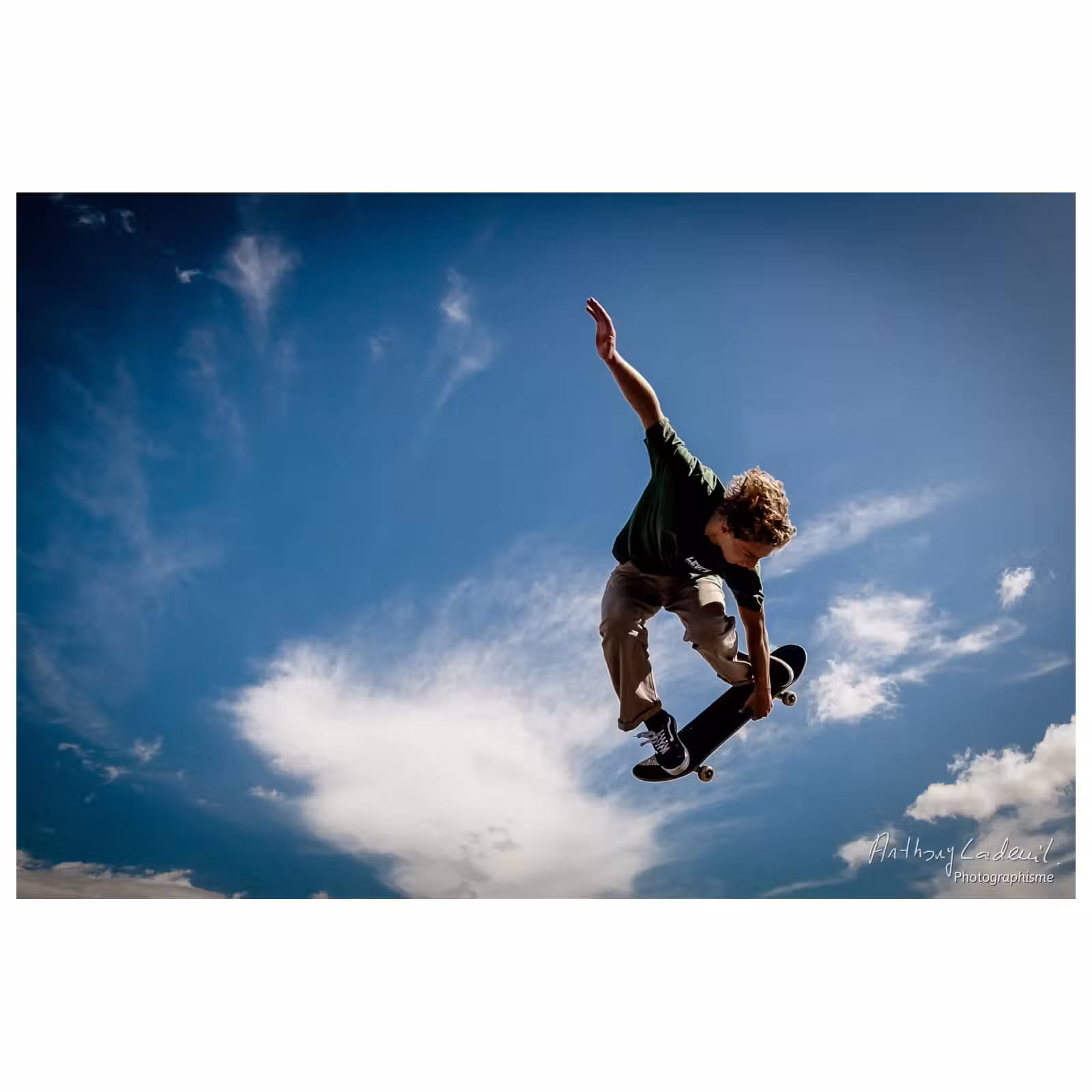 Photo d'un skater effectuant un saut sur fond de ciel