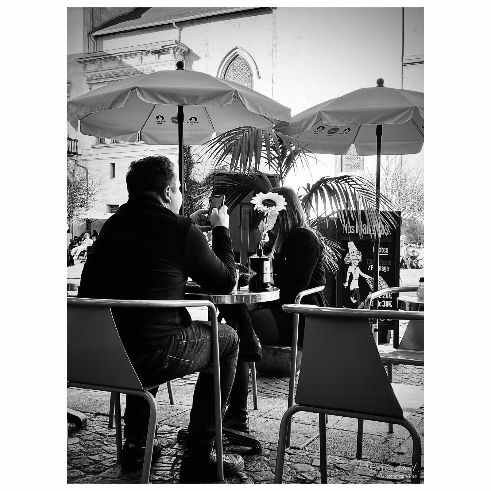un couple à table en terrasse de restaurant, chacun sur son téléphone portable