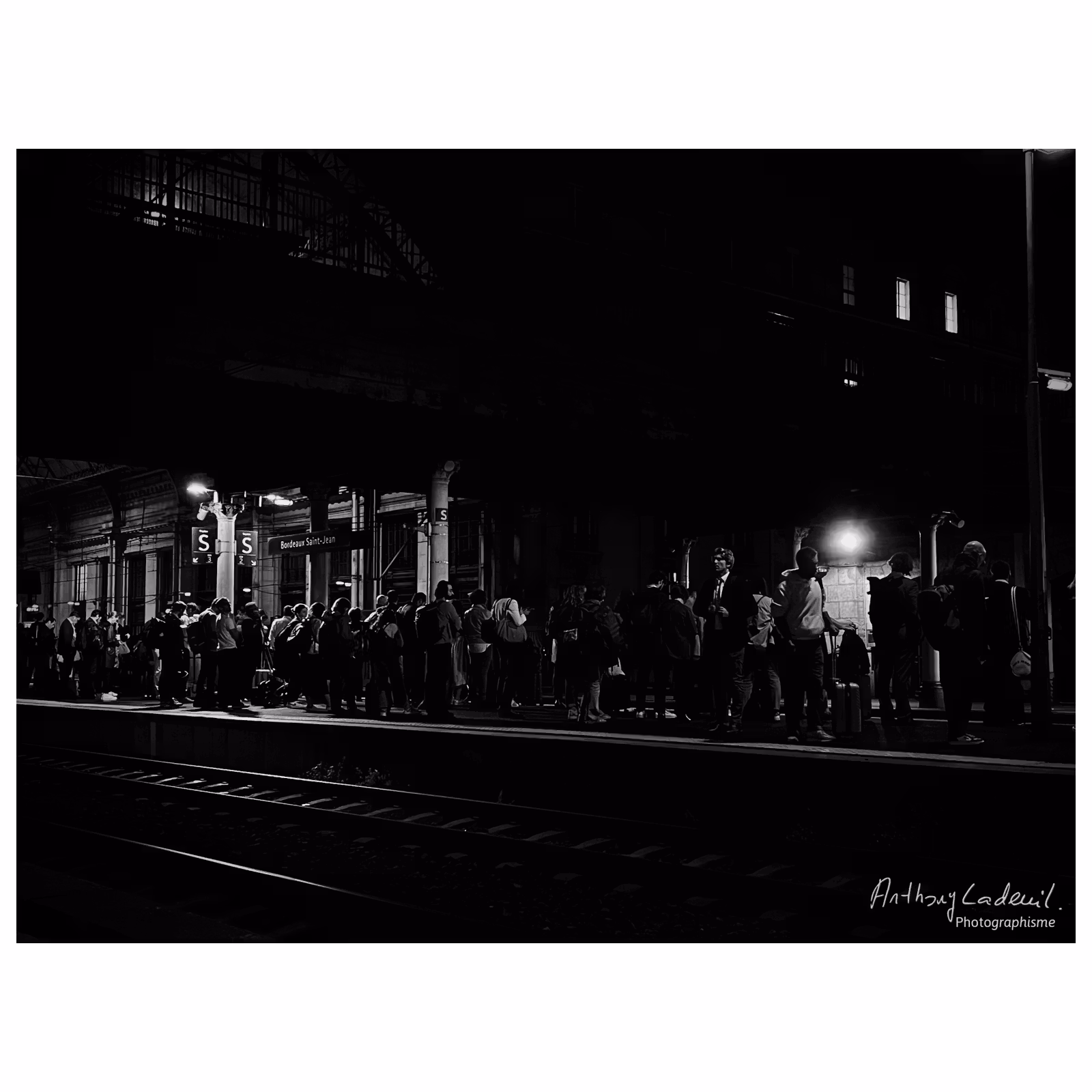 Quai de gare rempli de personnes dans la nuit