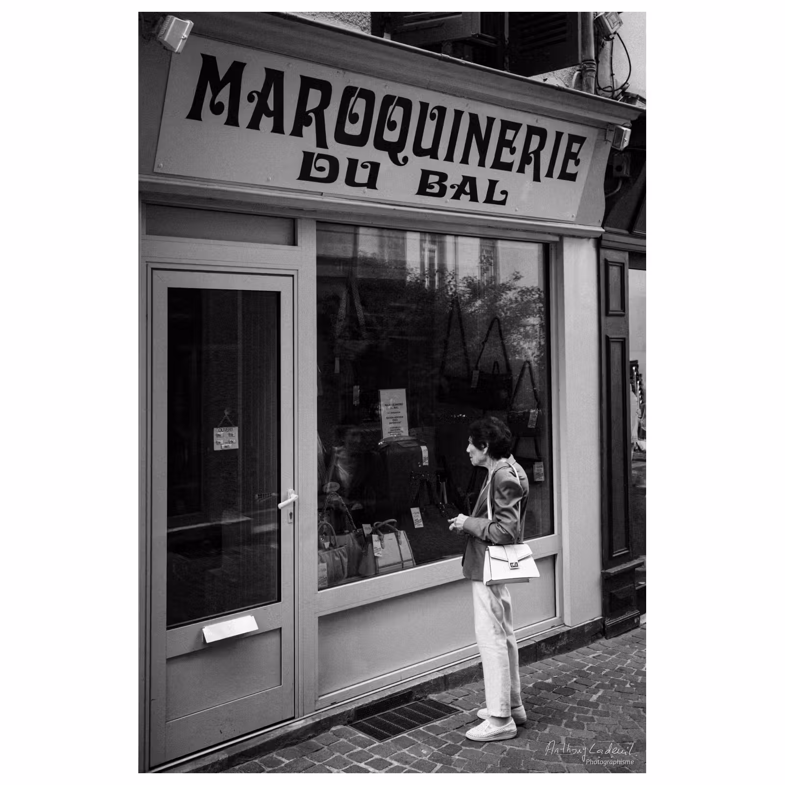 Femme regardant une devanture surannée de maroquinier