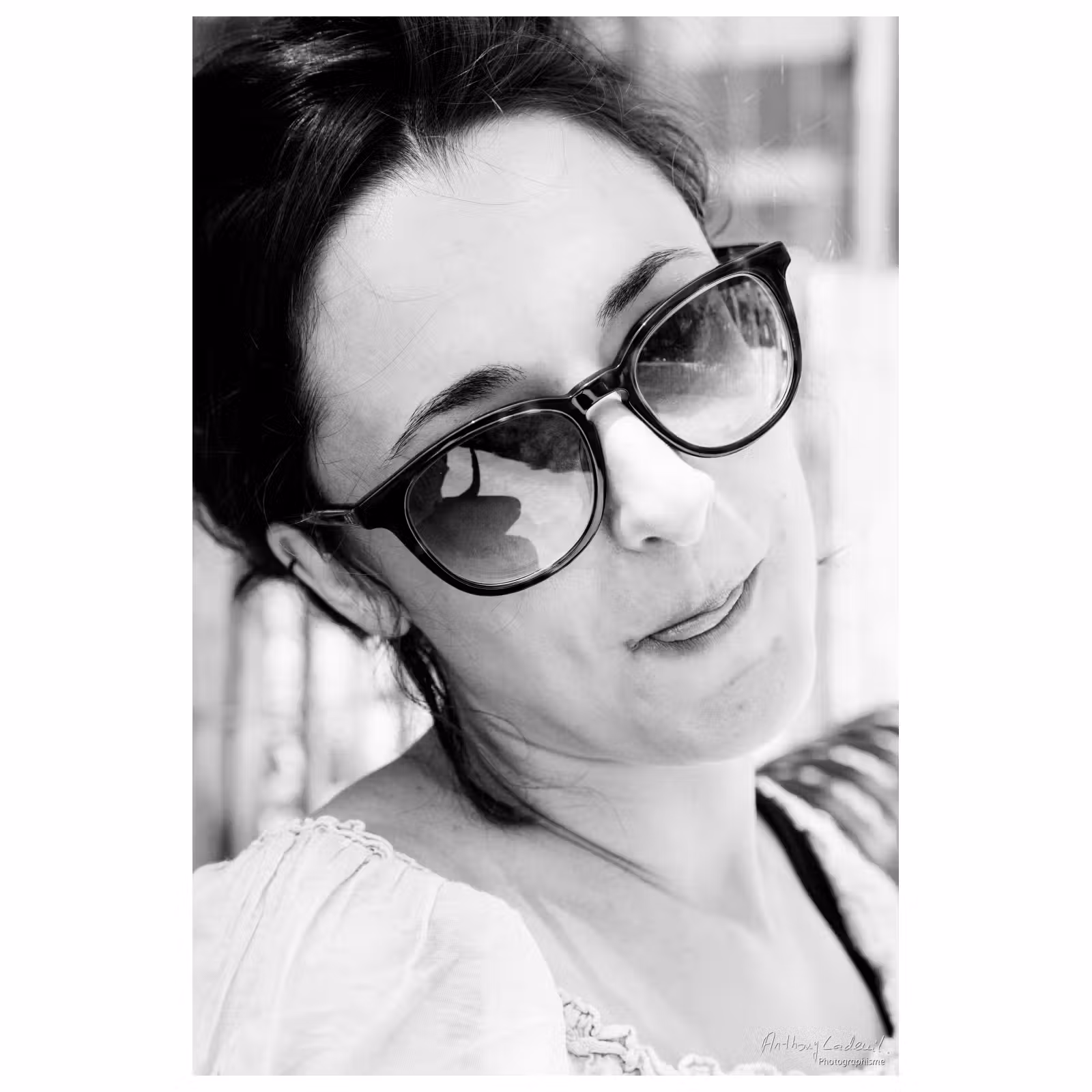 Portrait noir et blanc en extérieur d'une jeune femme tirant la langue