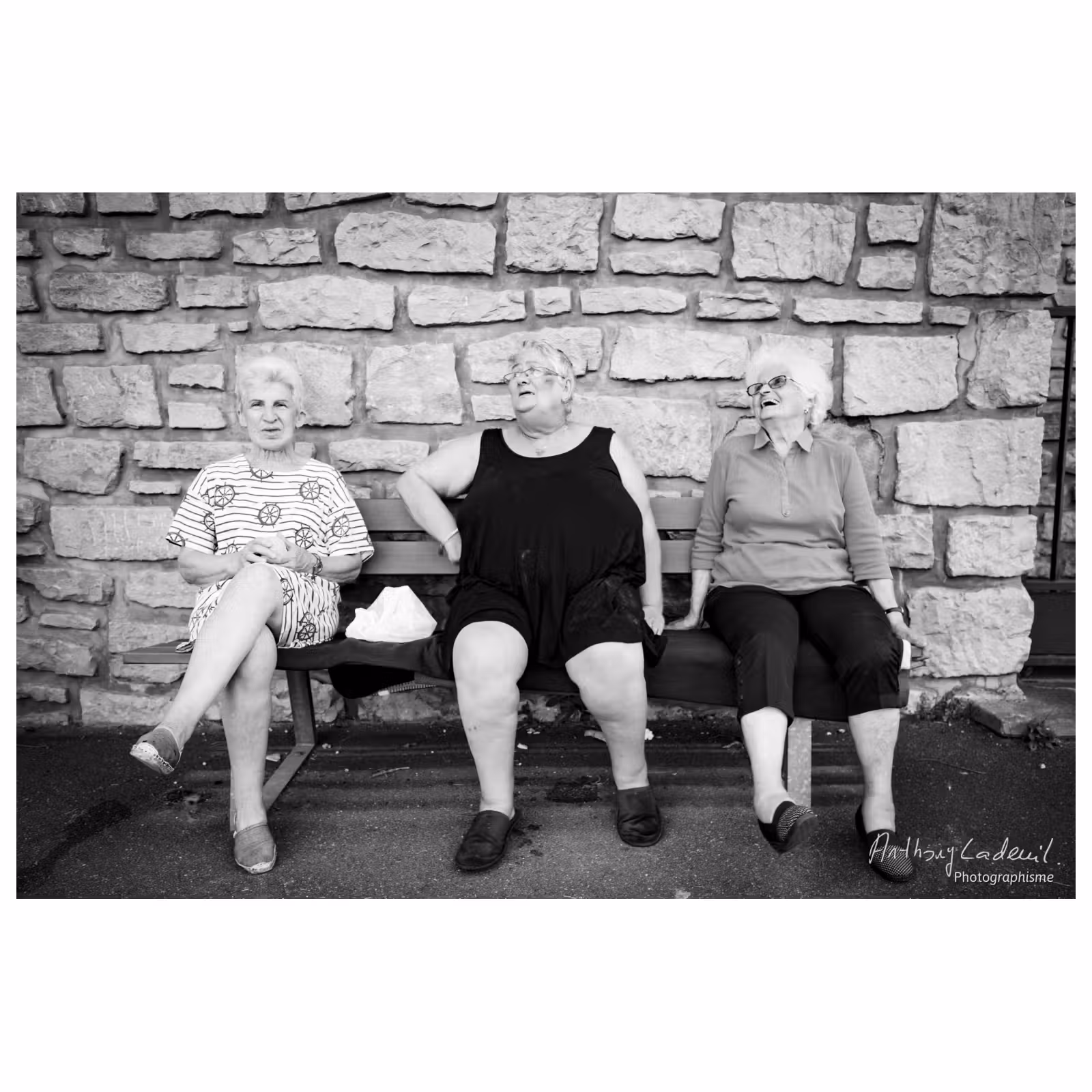 photographie de trois femmes âgées assises sur un bancs en ville