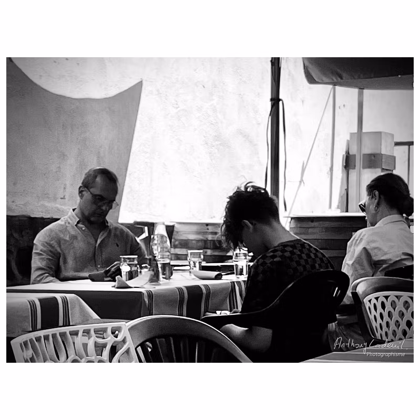 3 personnes au restaurant les yeux sur leurs téléphones