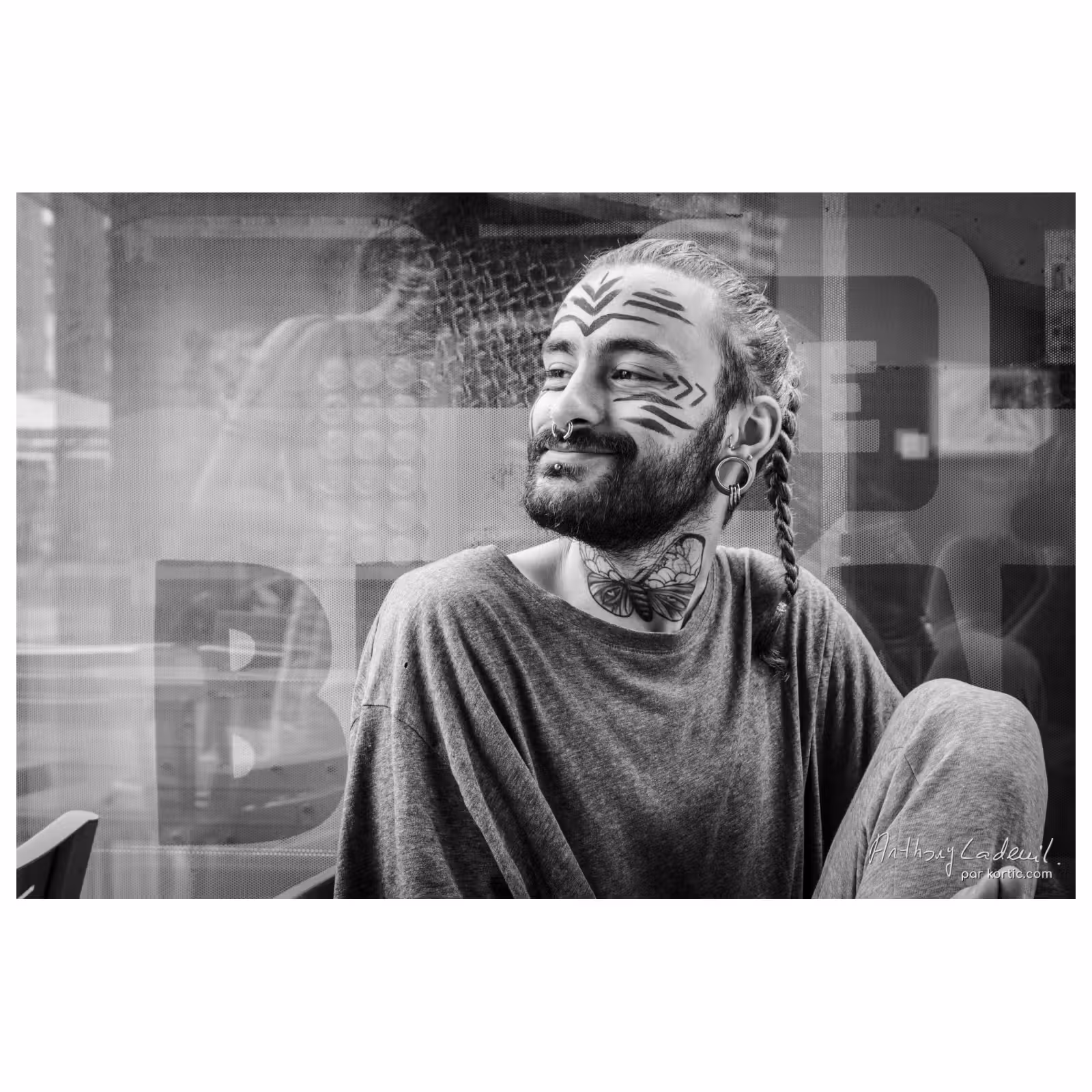 photographie en noir et blanc d'un jeune homme tatoué