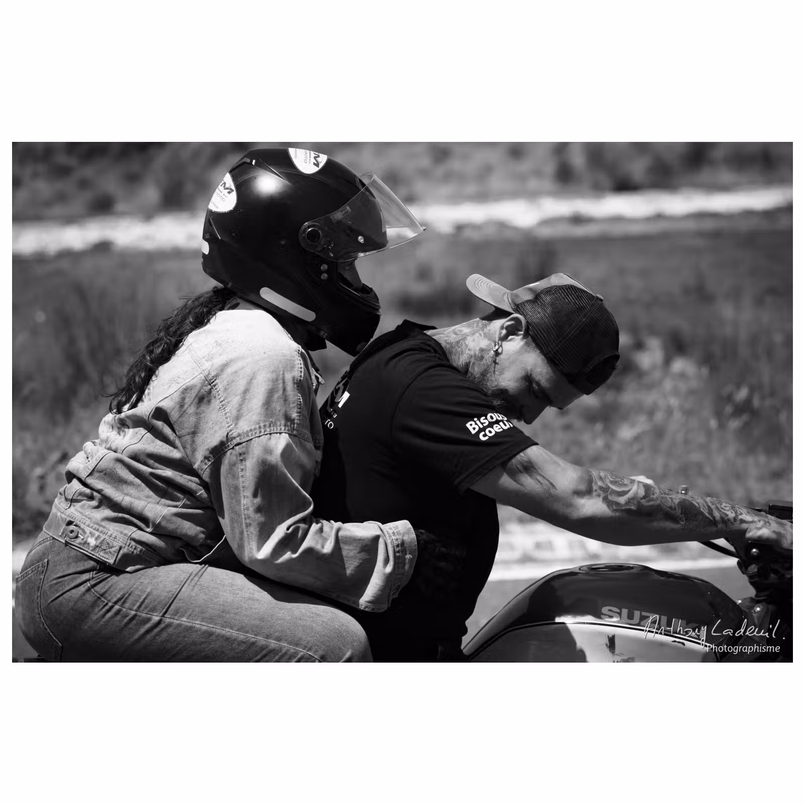 photographie en noir et blanc d'un moniteur de moto avec une passagère casquée