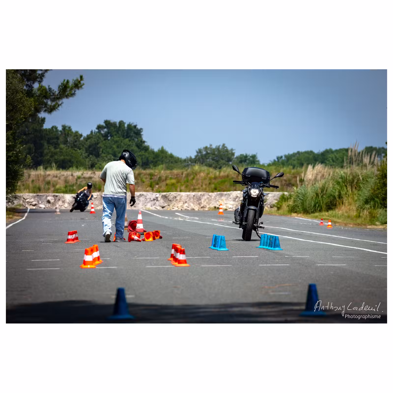un jeune homme ramasse des plots de slalom sur une piste de formation moto