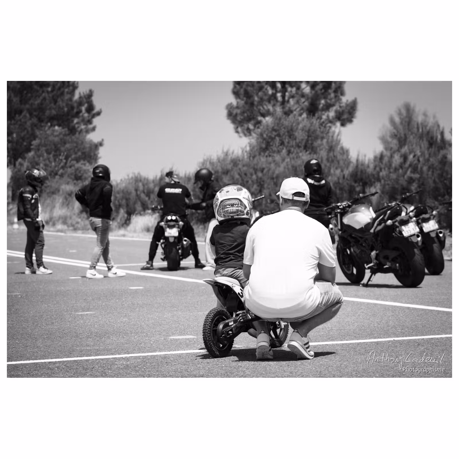 photo noir et blanc d'un jeune enfant sur une mini moto avec son père