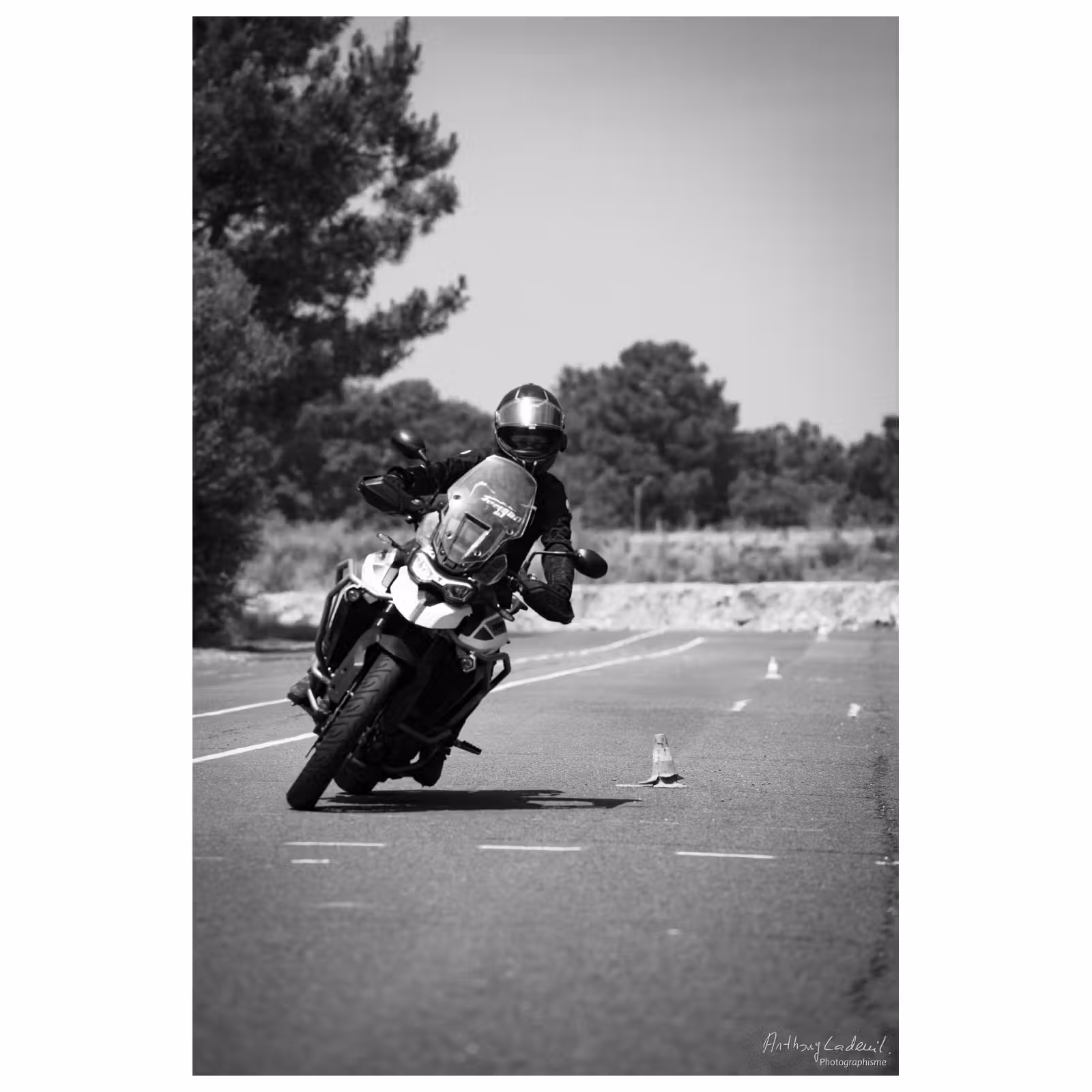 photographie noir et blanc d'une moto en slalom