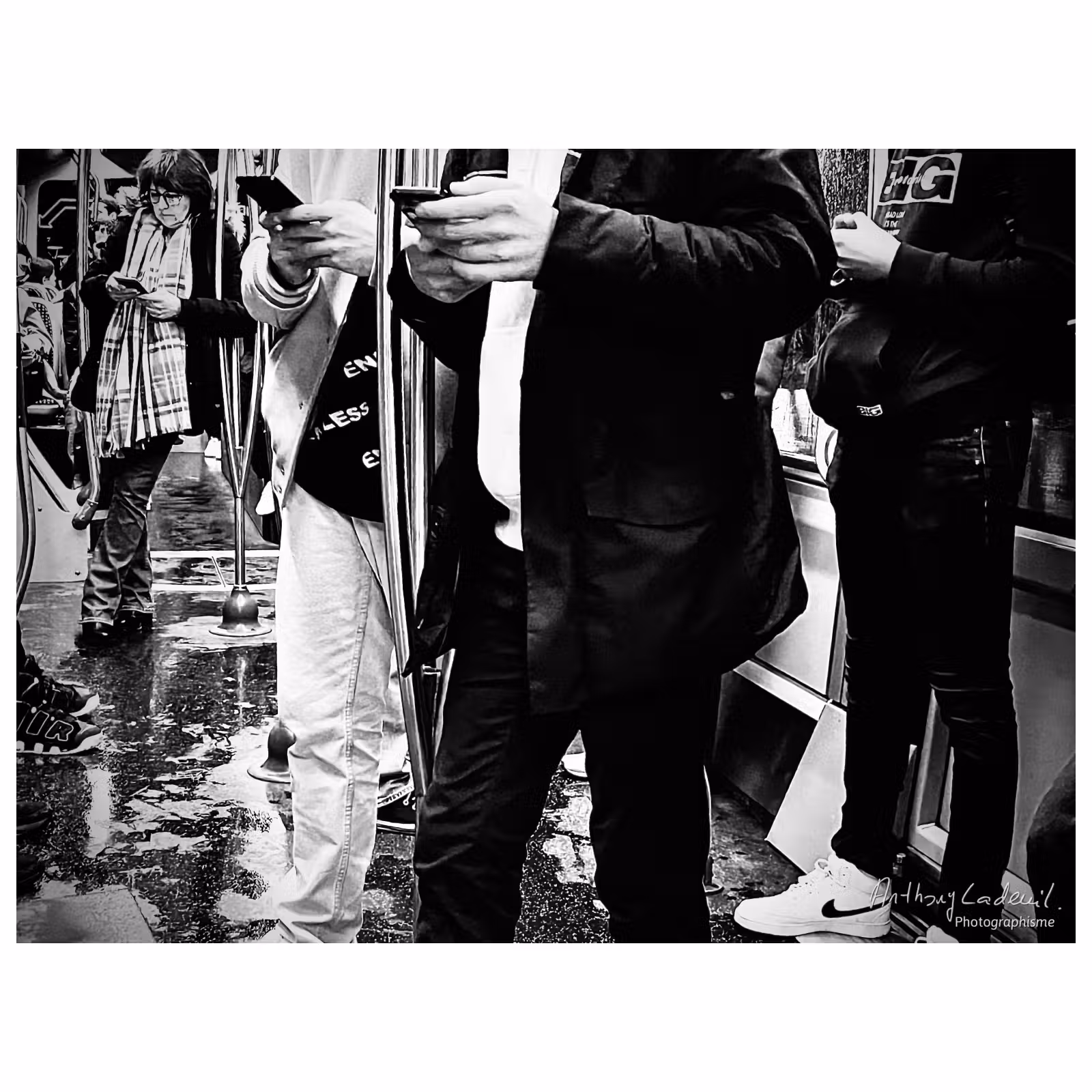 photo en noir et blanc de personnes rivées à leur téléphones dans un tramway