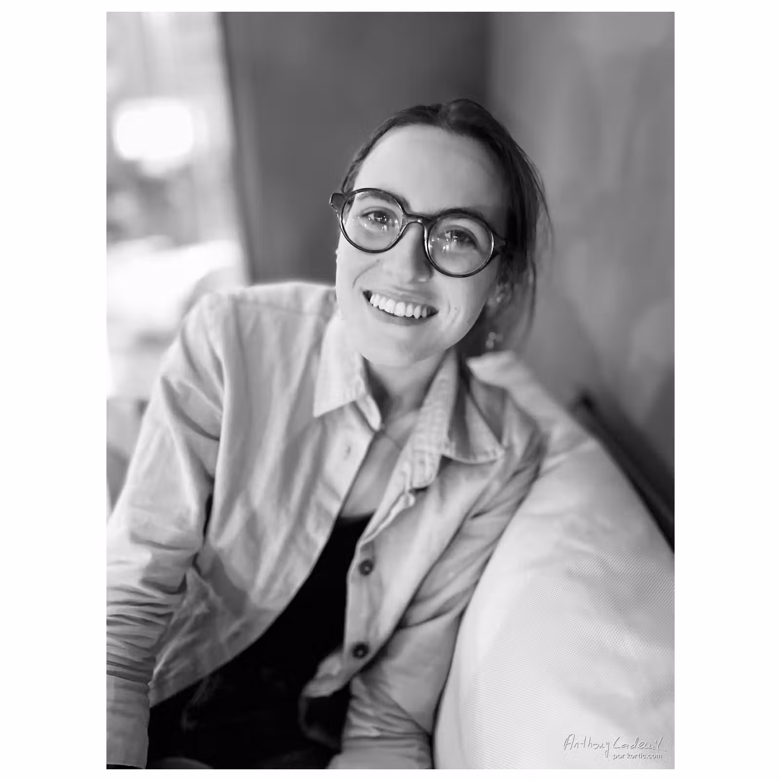 portrait d'une jeune femme portant des lunettes et souriante