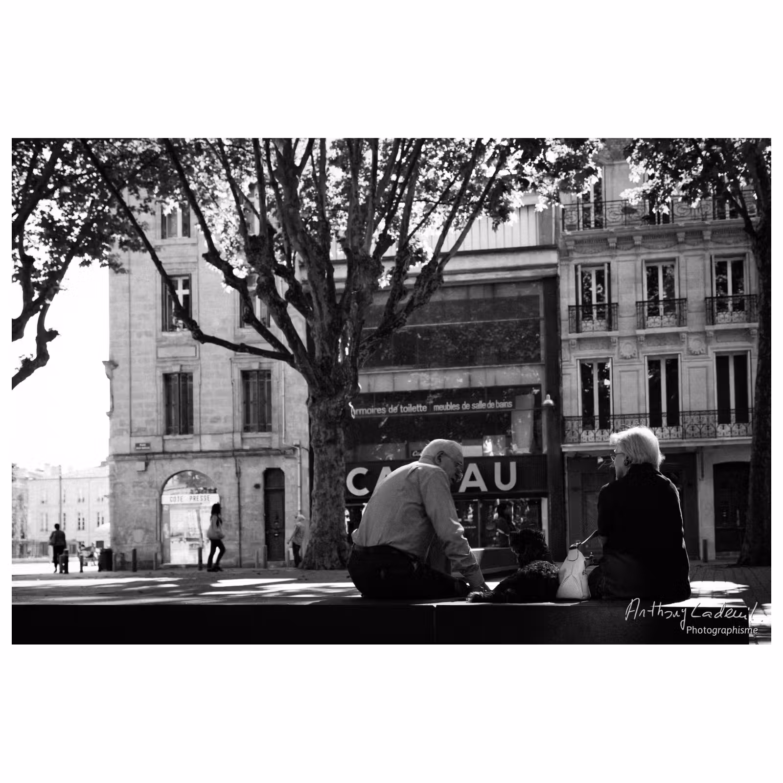 Photographie de rue sur les quais de Bordeaux. Deux personnes âgées sur un banc avec leur chien.
