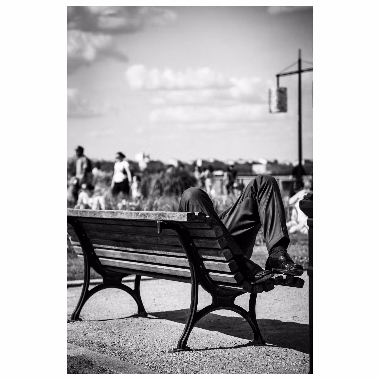 Photographie de rue sur les quais de Bordeaux. Un homme allongé sur un banc.