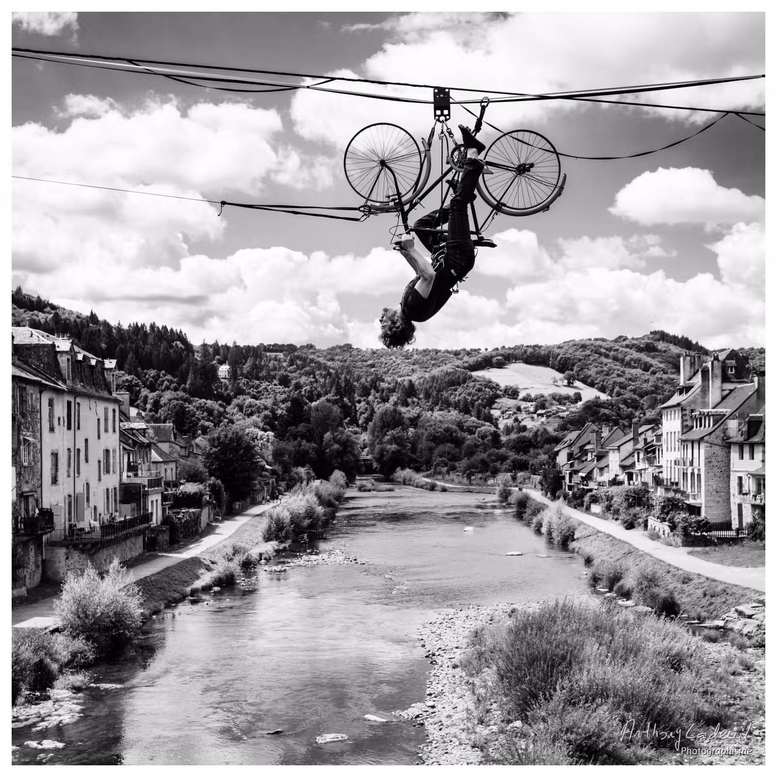 un homme en équilibre sur un vélo renversé sur une corde tendue