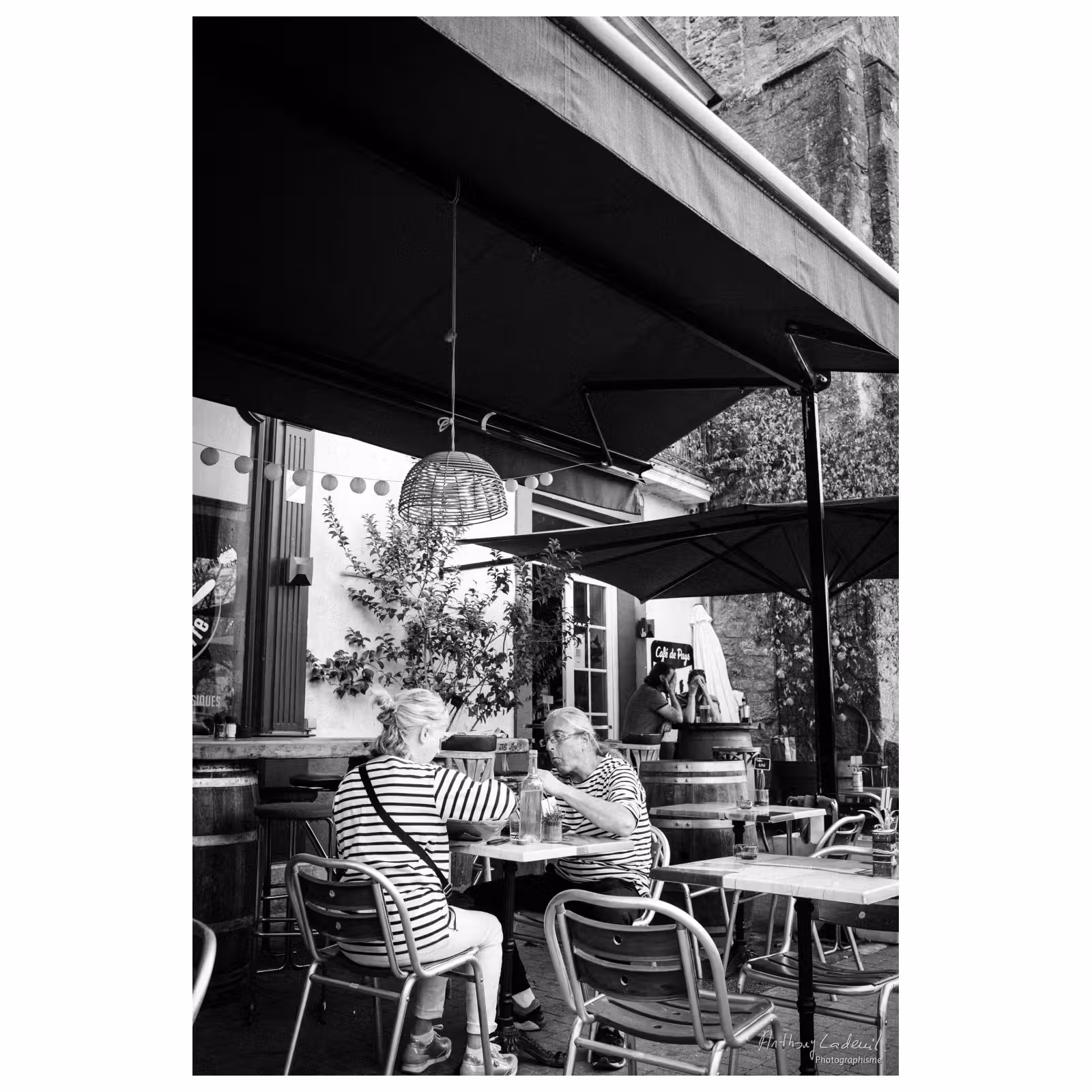 photographie d'un couple portant des marinières, déjeunant à la terrasse d'un café