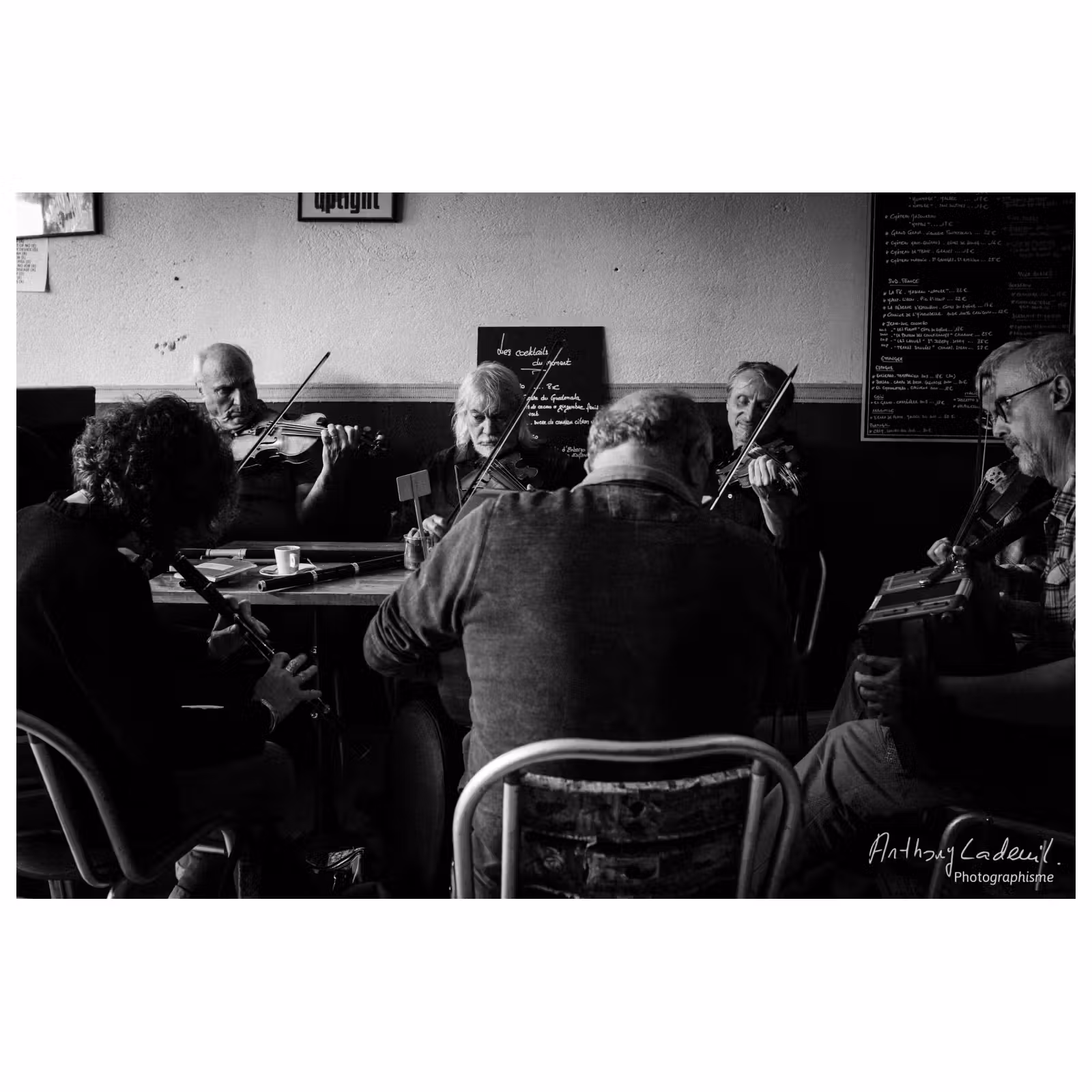 photographie d'un groupe de musiciens assis autour d'une table