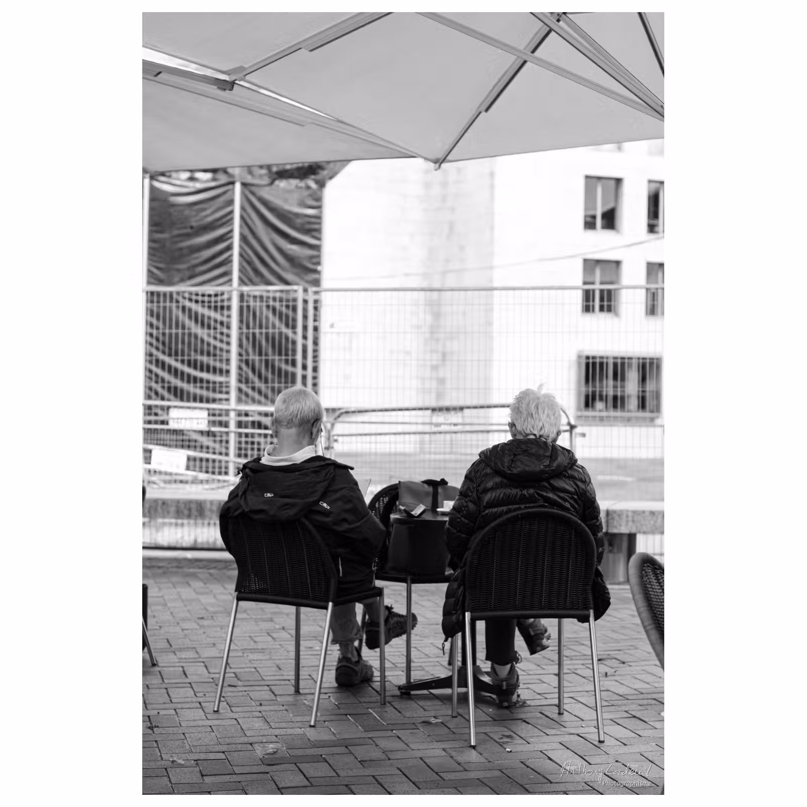 Deux personnes âgées de dos à une terrasse de café