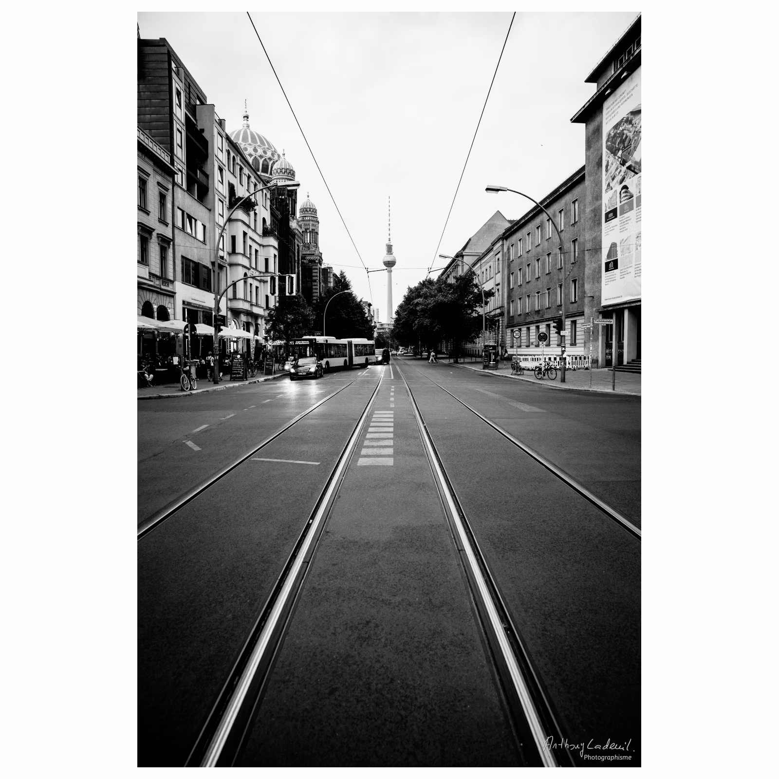 vue fuyante de rails de tramway dans une rue de Berlin avec la tour Fernsehturm de Berlin en arrière plan