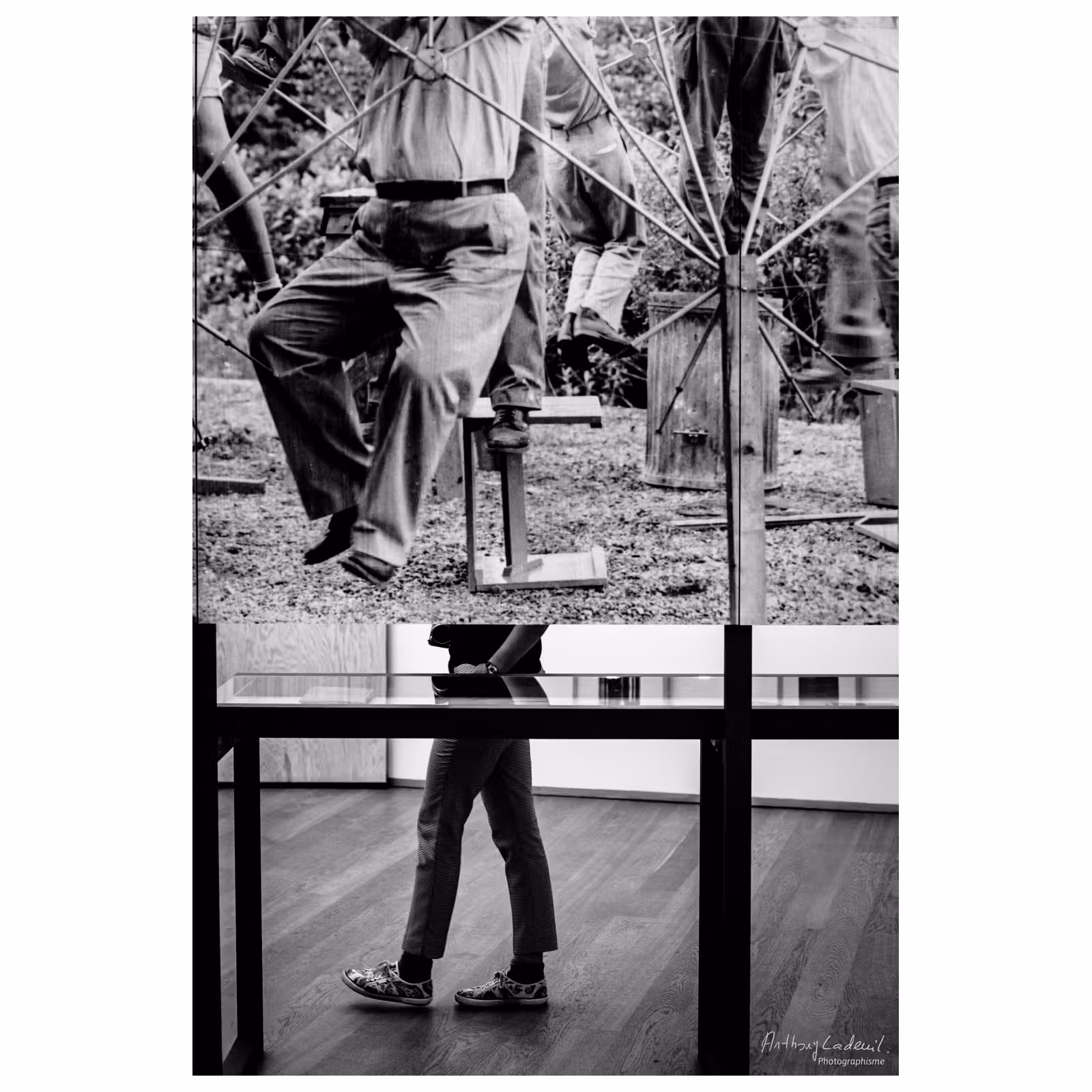 photographie des jambes d'une personne passant derrière un tableau dans un musée