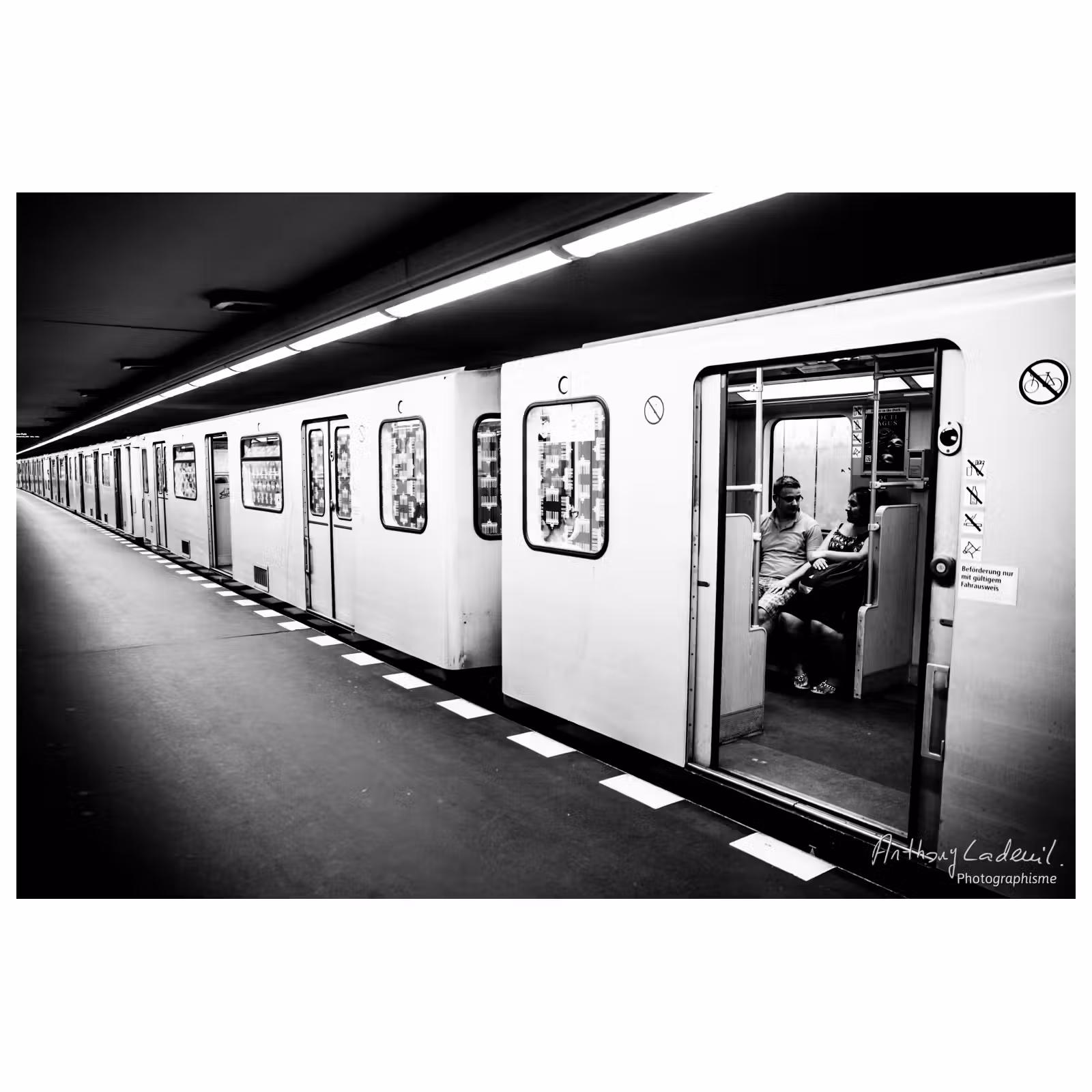 deux personnes assises seules dans le metro berlinois à l'arrêt