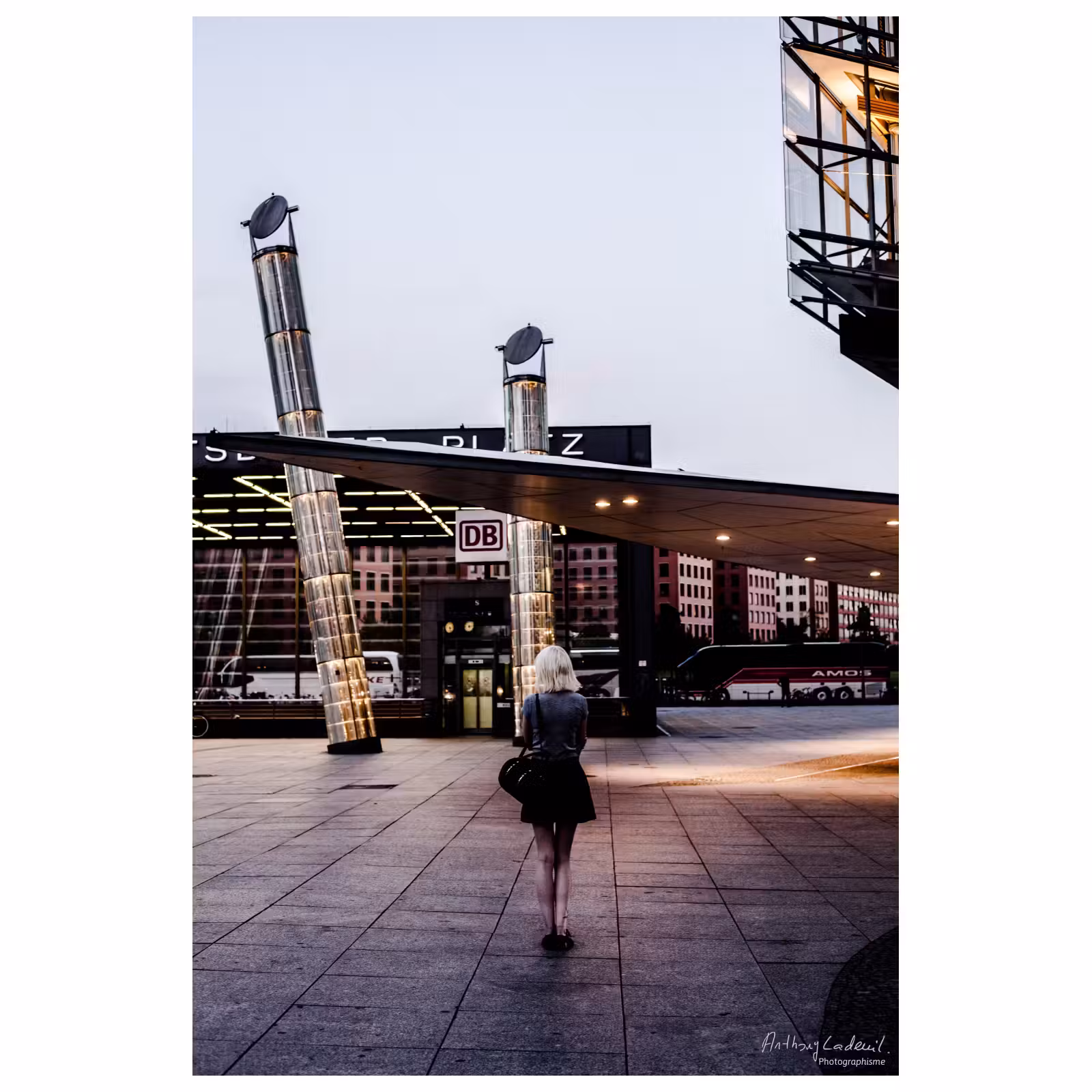 femme de dos seule sur une place fréquentée de Berlin