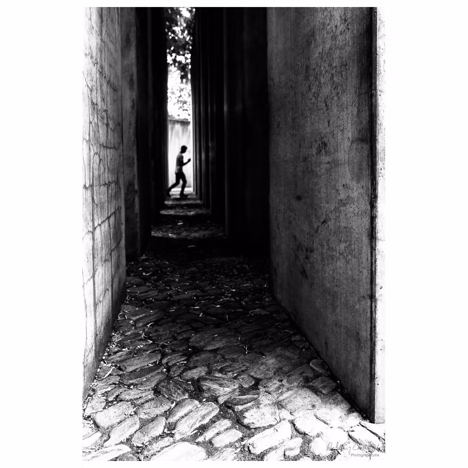 personne à contre jour marchant entre des blocs de béton au musée Juif de Berlin