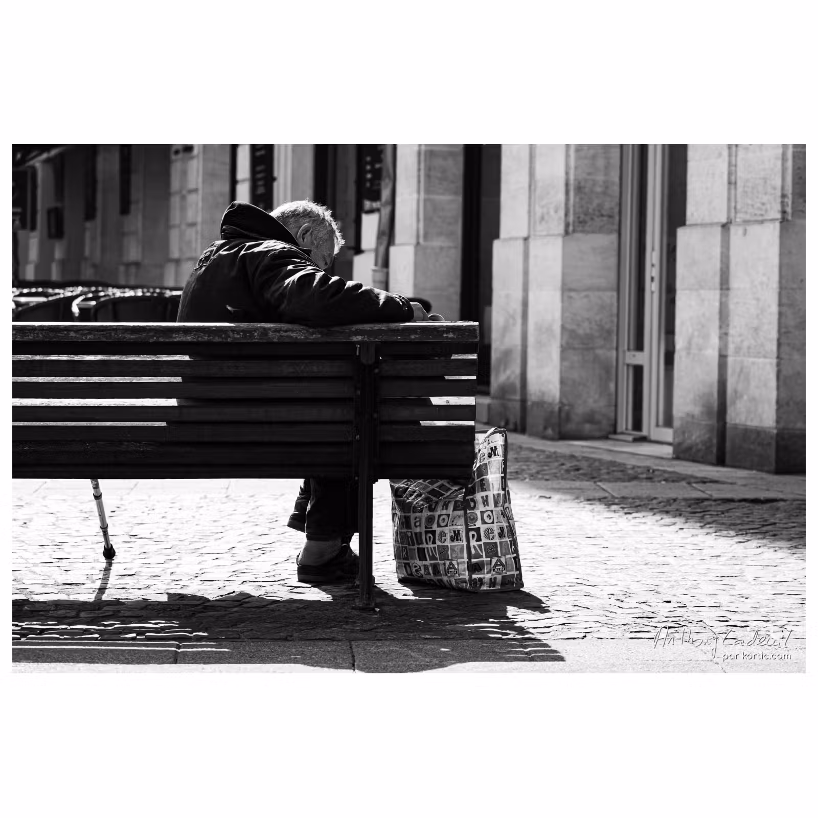 homme âgé en train de lire le journal sur un banc