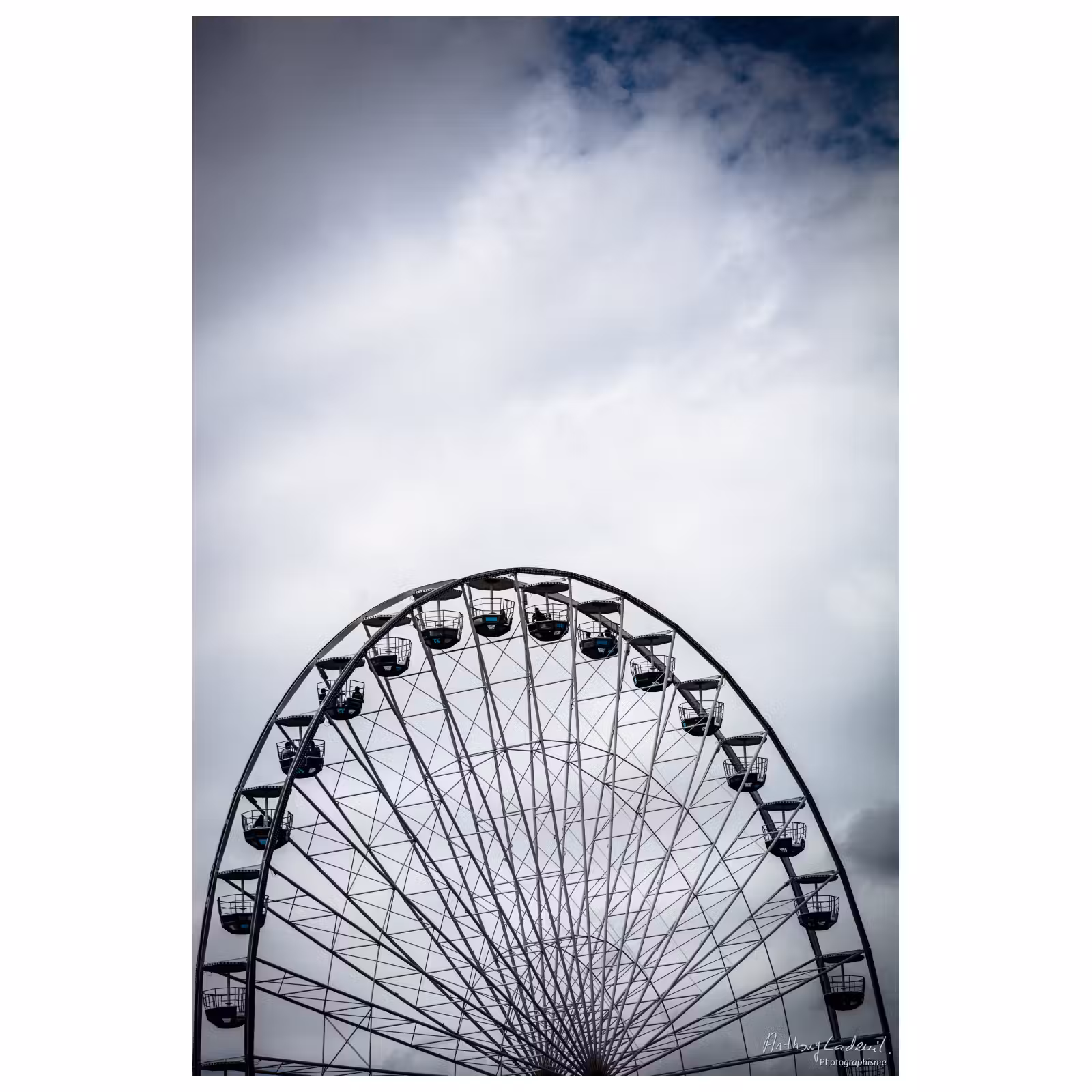 photographie d'une grande roue sur fond de ciel nuageux