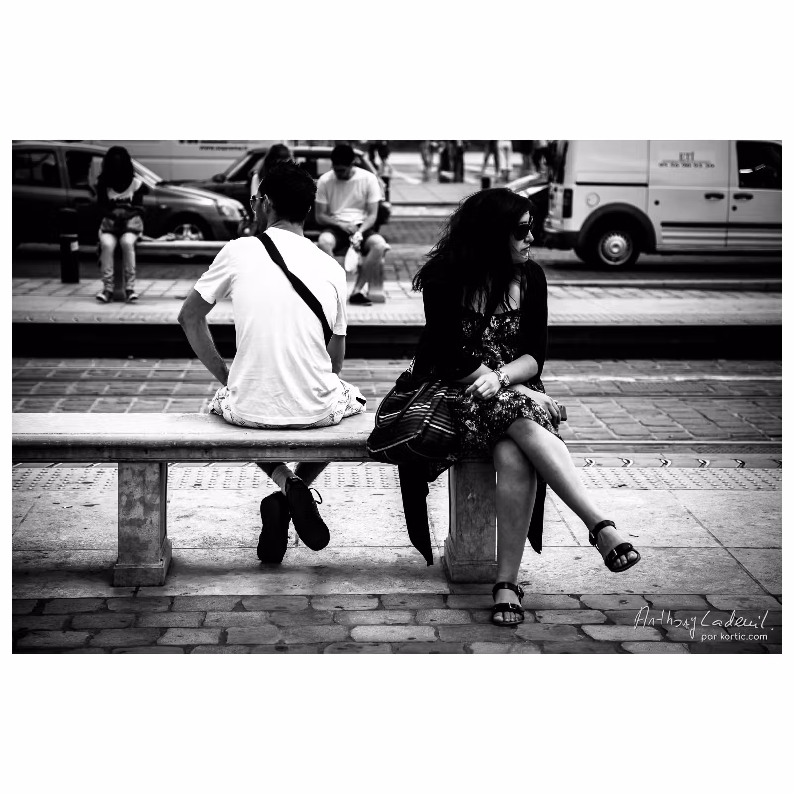 une femme et un homme assis dos à dos sur un banc