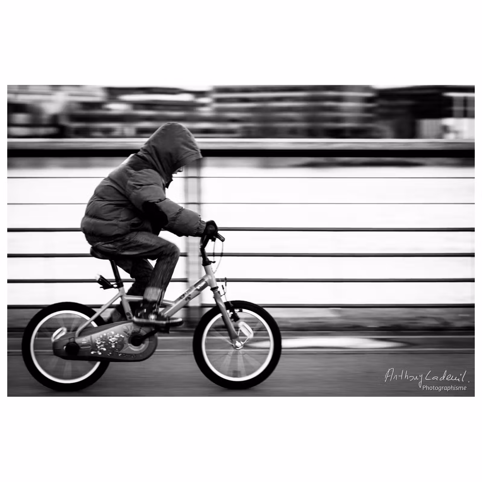 photographie avec un effet filé d'un jeune enfant à vélo