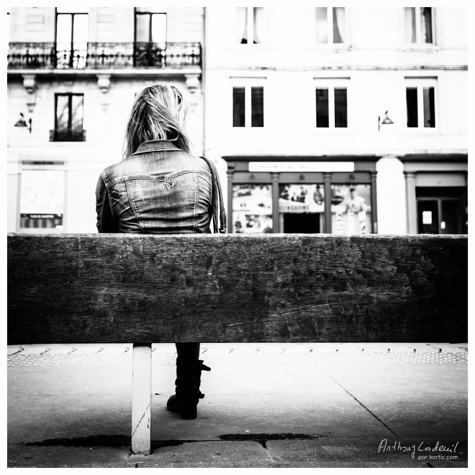 femme assise sur un banc public vue de dos