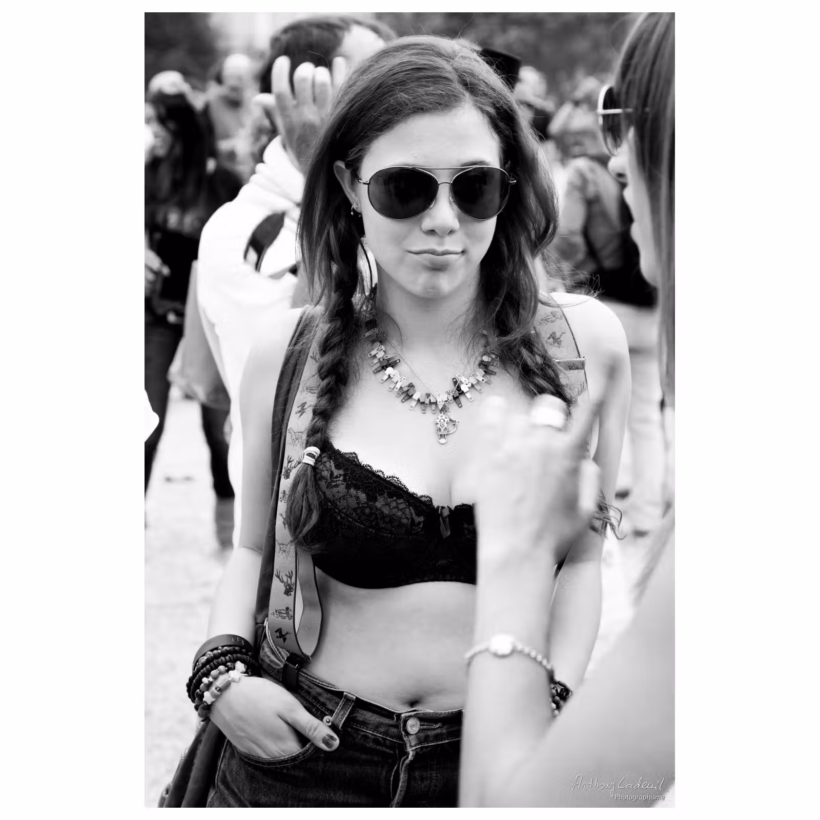 portrait d'une jeune femme en soutien gorge portant des lunettes noires lors d'une gaypride