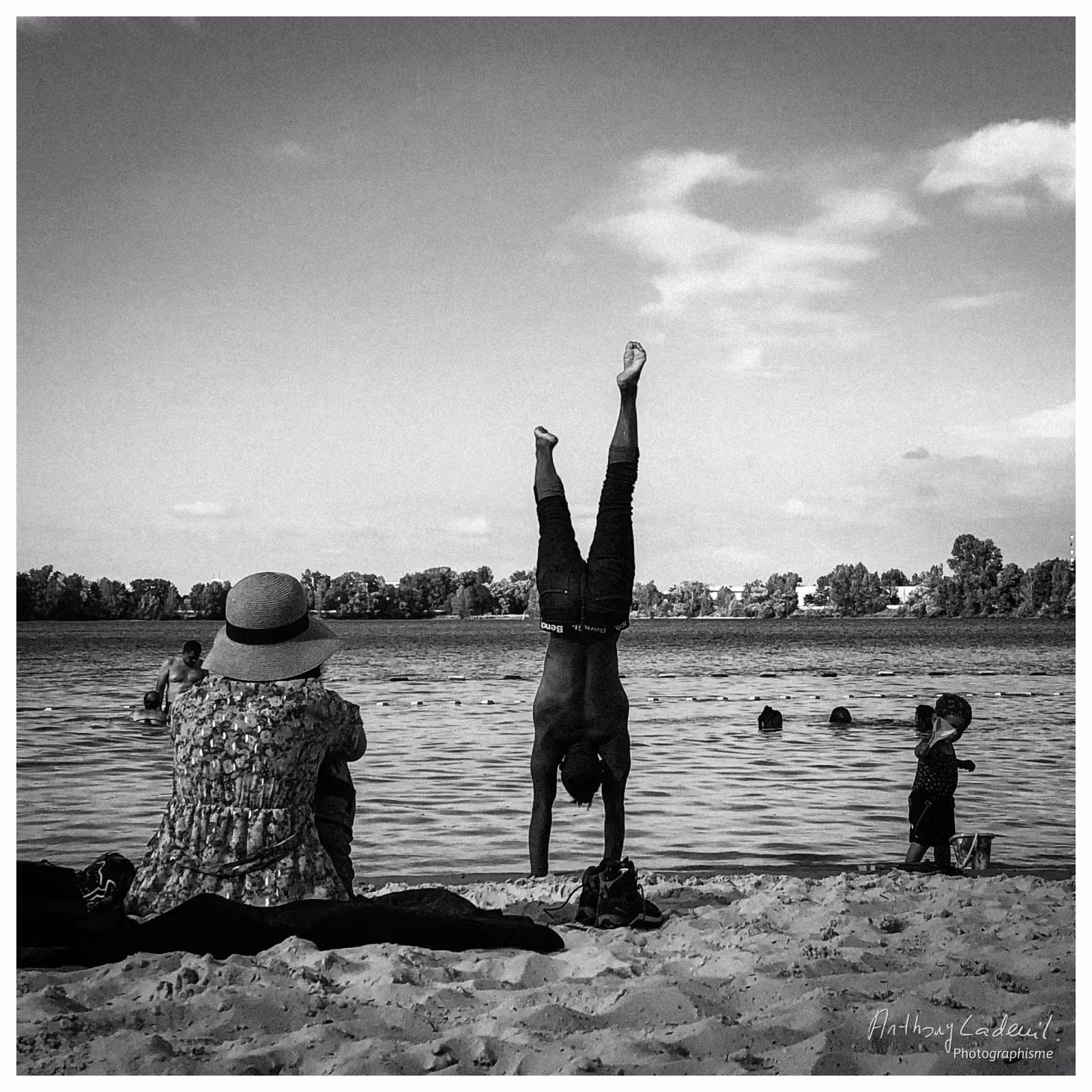 photographie d'une famille au bord d'un lac et un homme faisant le poirier