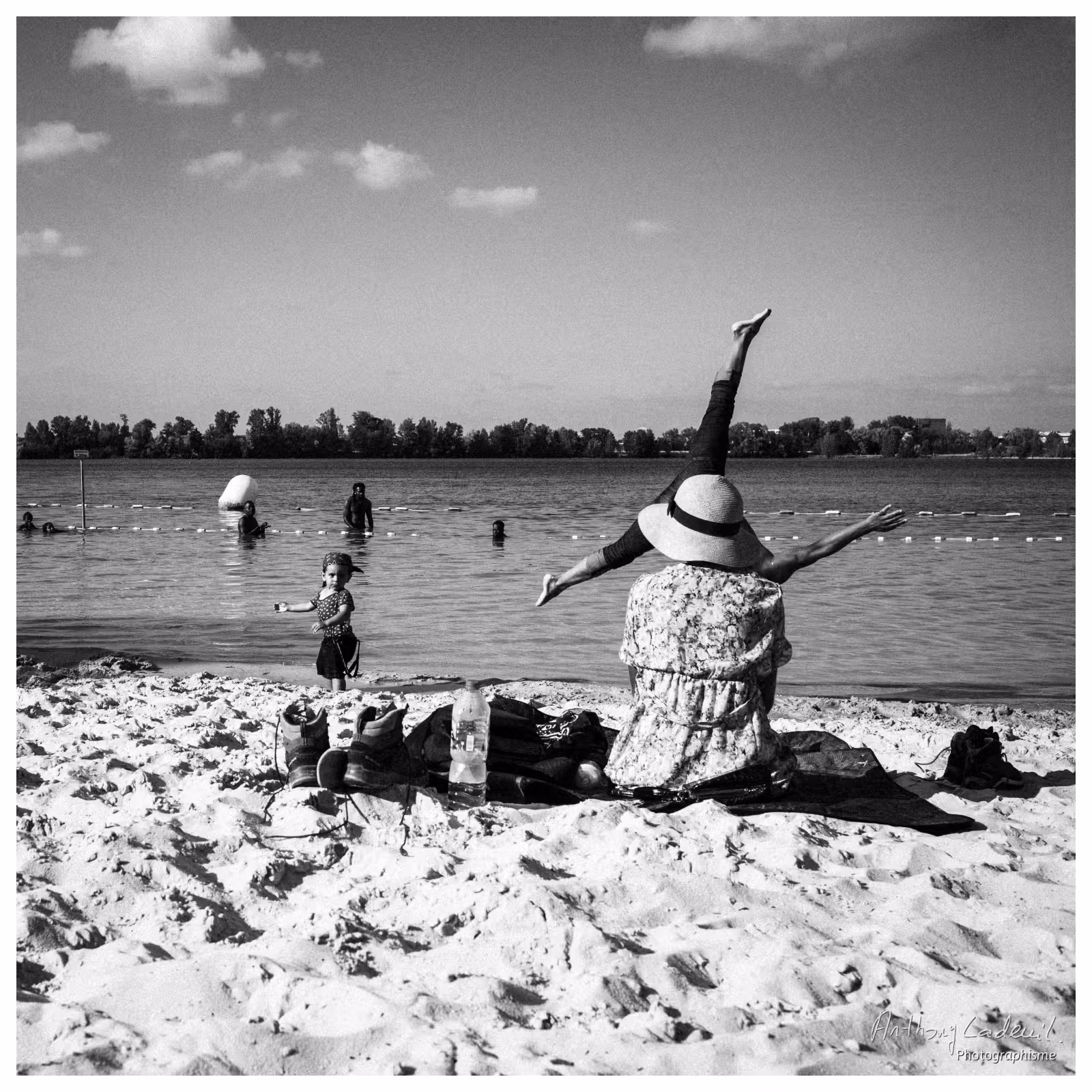 photographie d'une famille au bord d'un lac et un homme faisant la roue