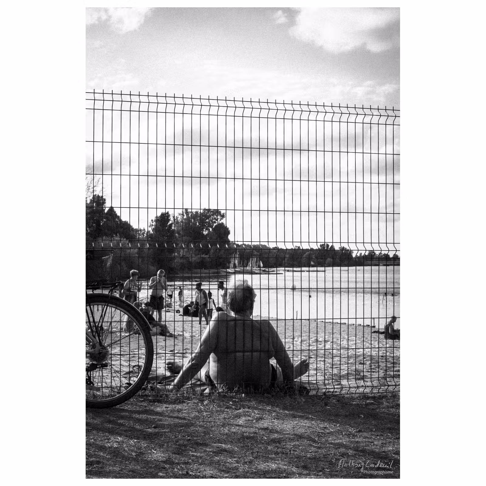 photographie d'un homme en maillot de bain contre un grillage