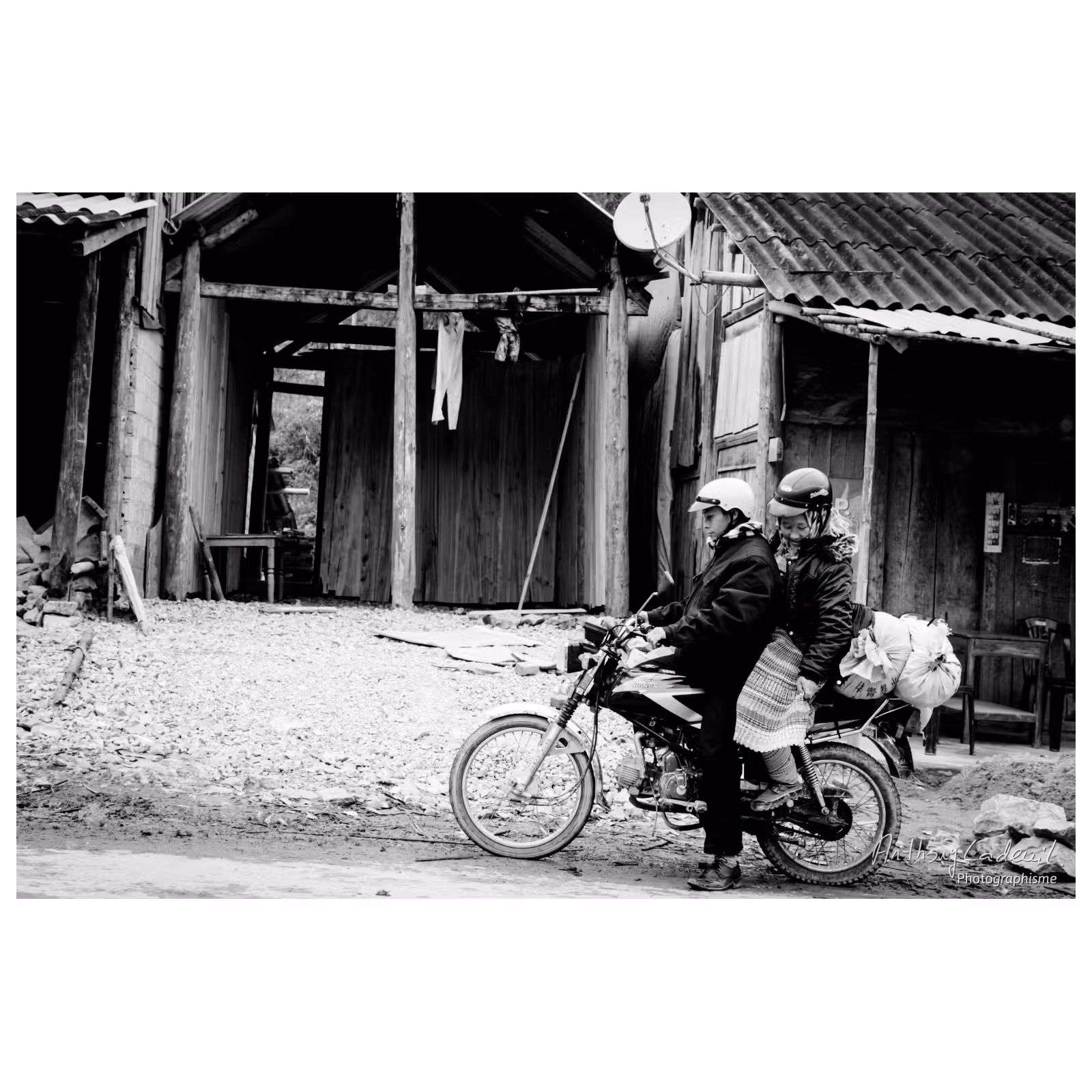 femme vietnamienne en tenue traditionnelle assise derrière un homme sur une moto