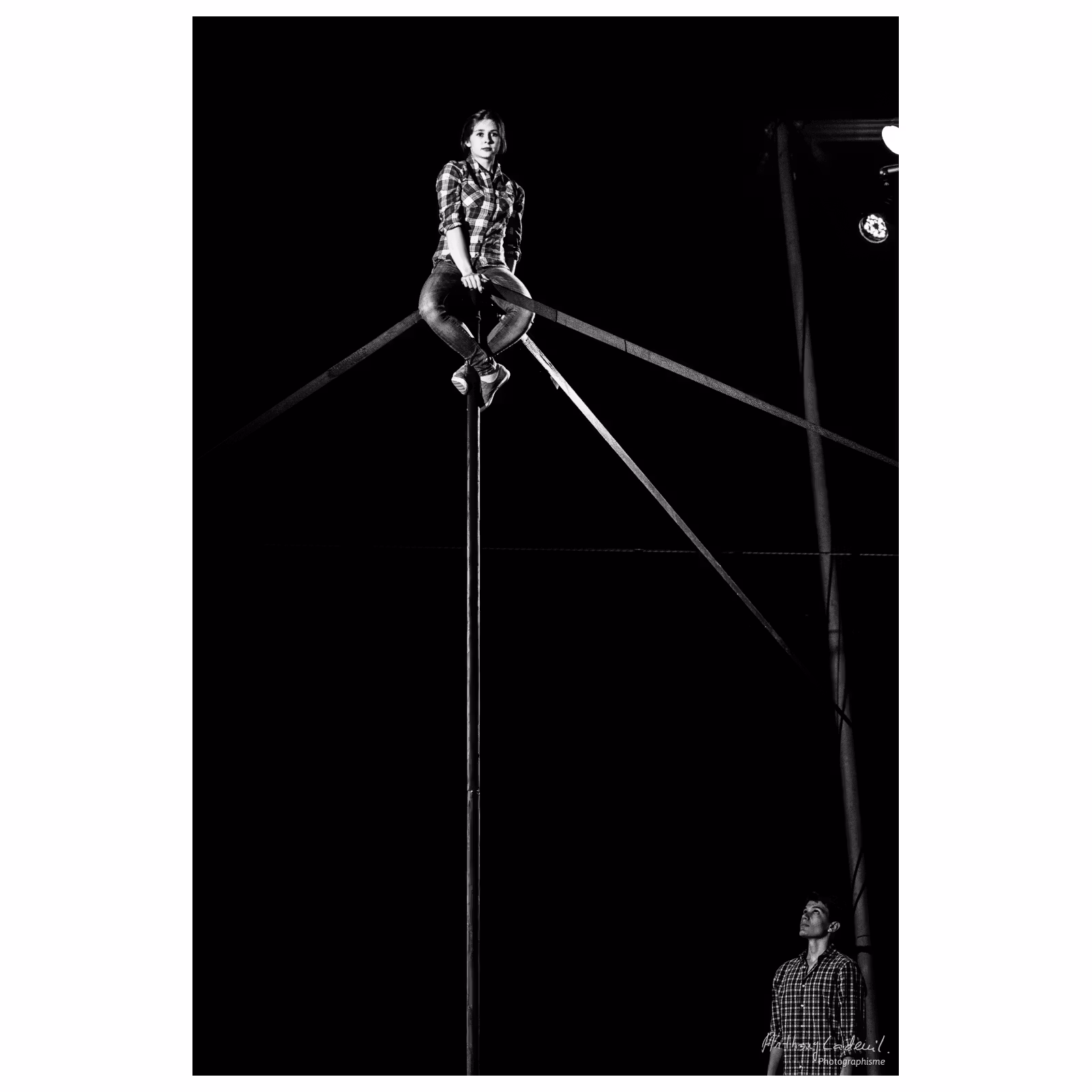 jeune femme artiste de cirque assise en haut d'un mat