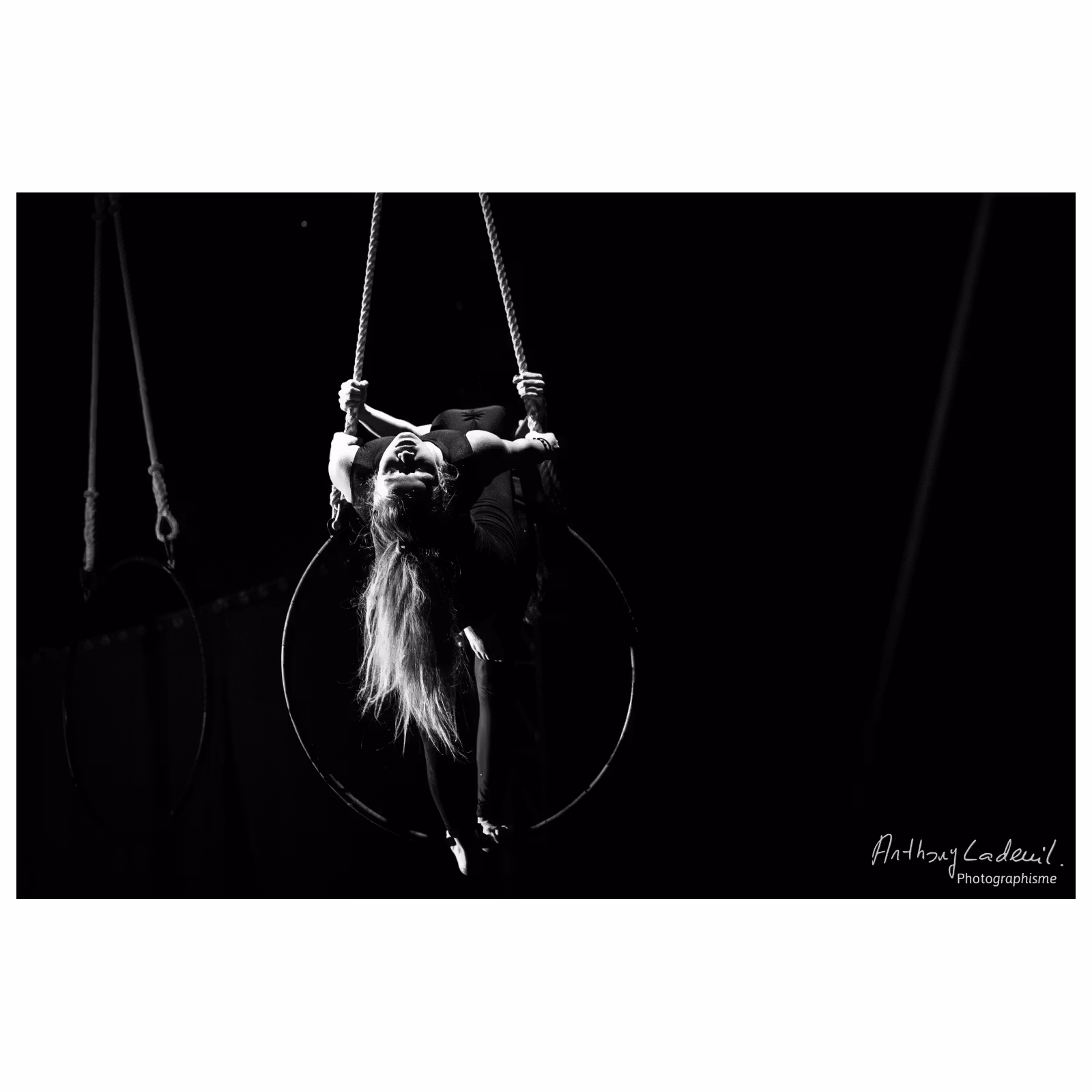 jeune femme artiste de cirque effectuant une figure suspendue sur un anneau