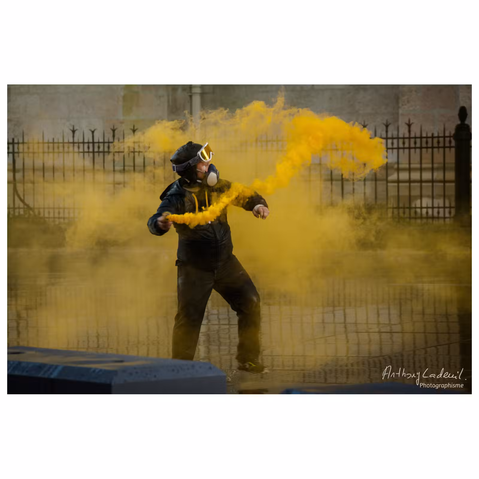 un homme casqué est entouré d'un fumigène jaune
