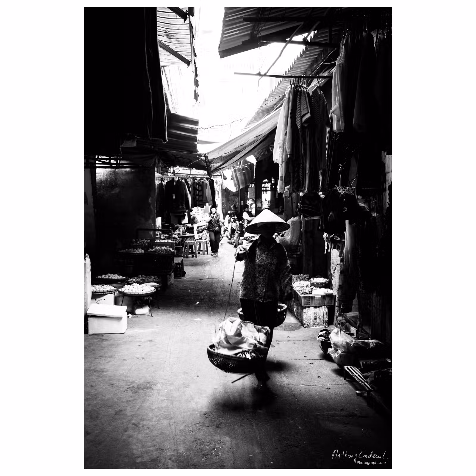 femme vietnamienne à contre jour dans les allées d'un marché