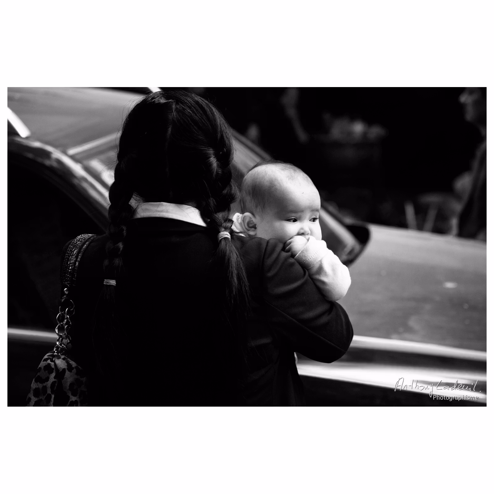 portrait d'une femme vietnamienne portant son enfant dans une rue de Hanoï