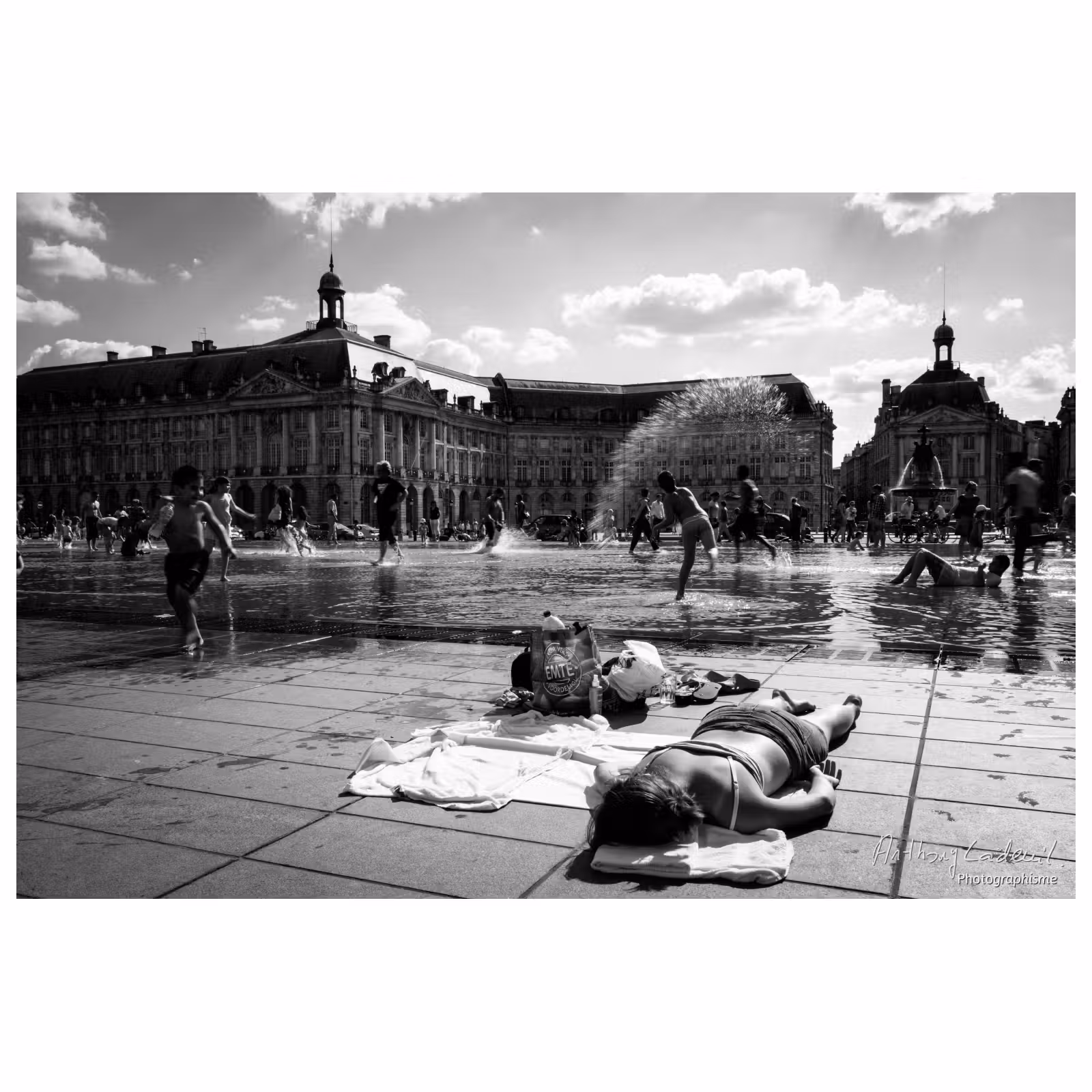 personne allongée en maillot de bain au bord d'un miroir d'eau en ville