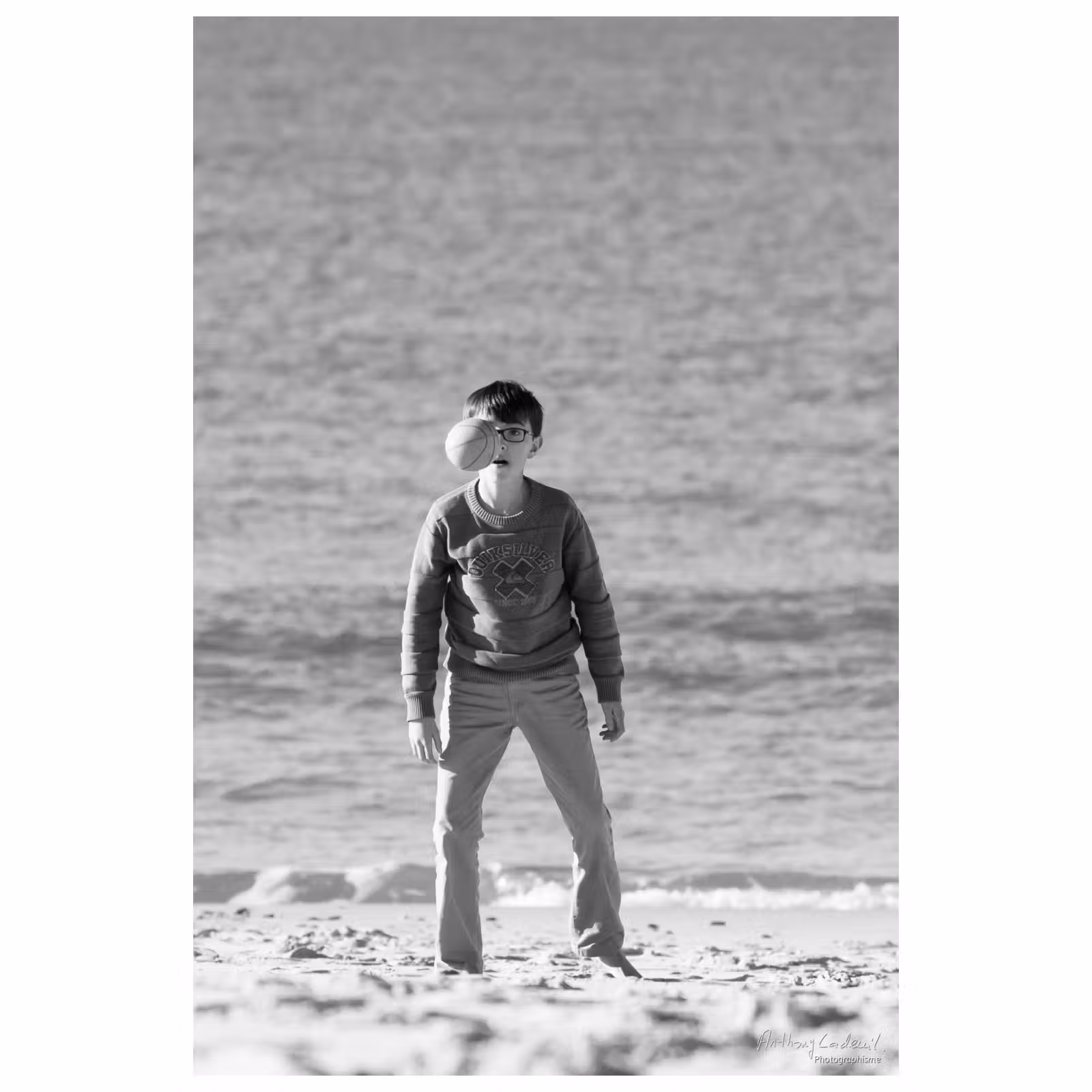 enfant jouant sur le sable avec un ballon