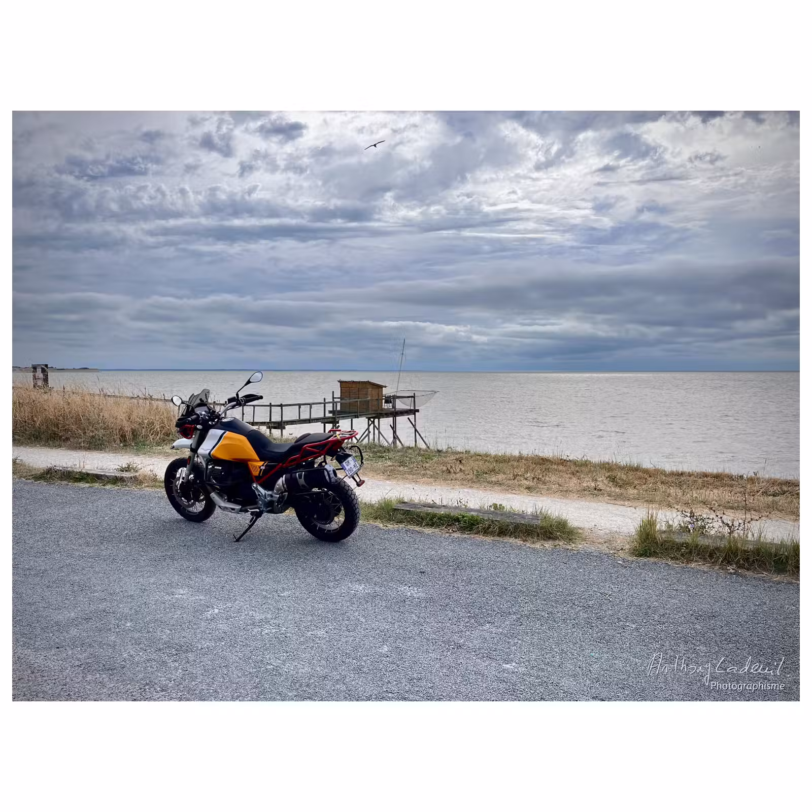 photographie d'un bord de mer avec une Moto Guzzi au premier plan