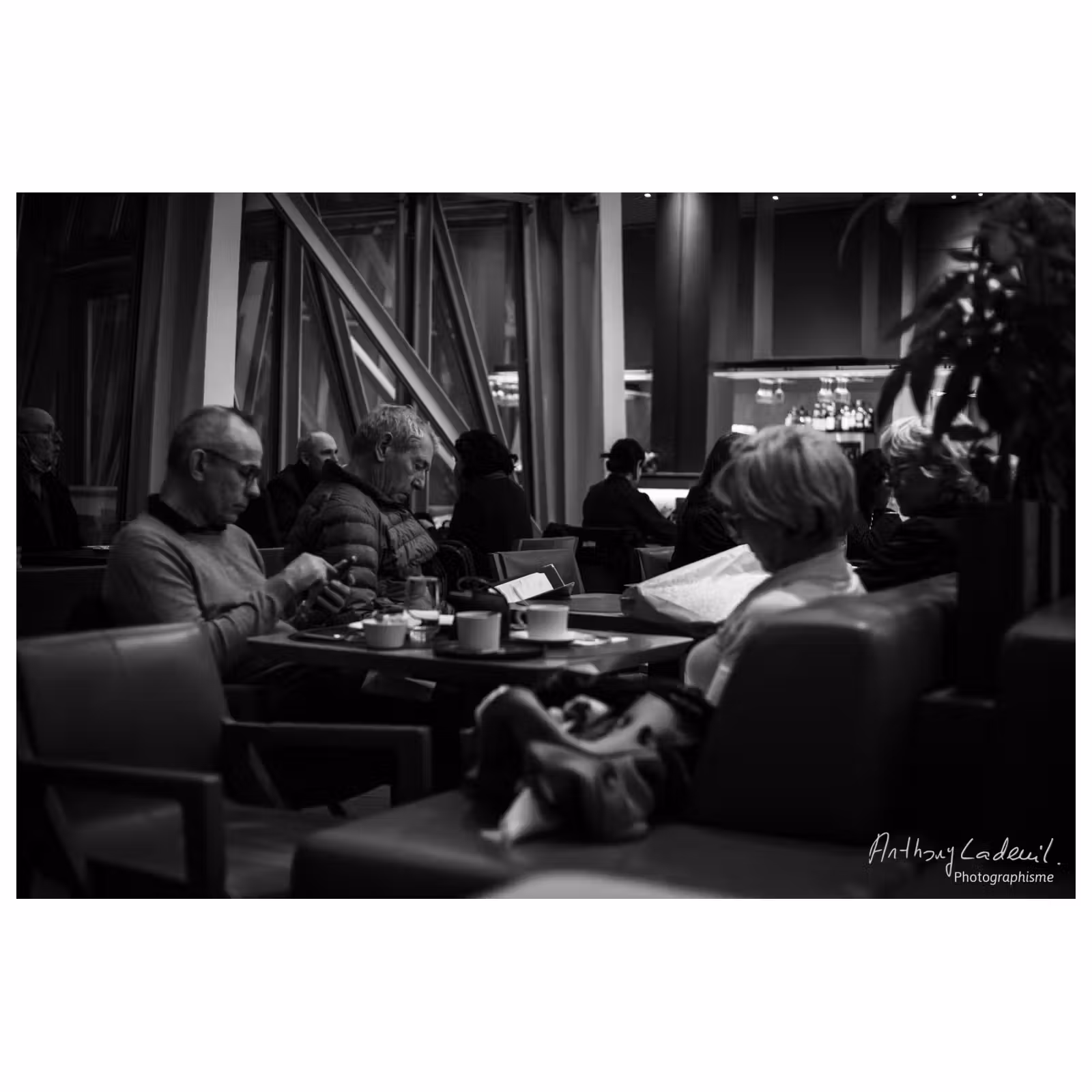 photographie de personnes regardant leurs téléphones autour d'une table dans un bar