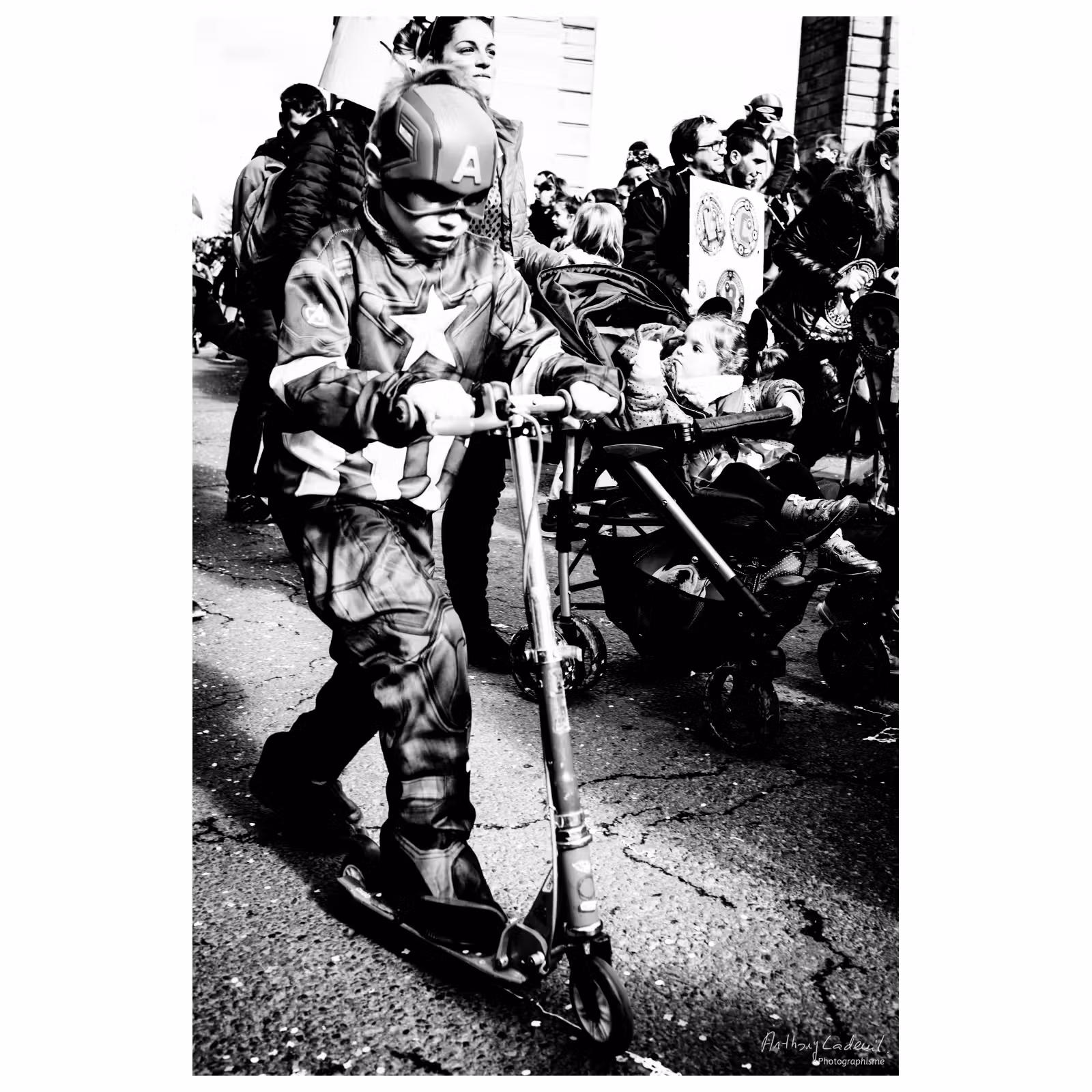 un enfant déguisé en Capitaine America sur une trottinette dans la rue