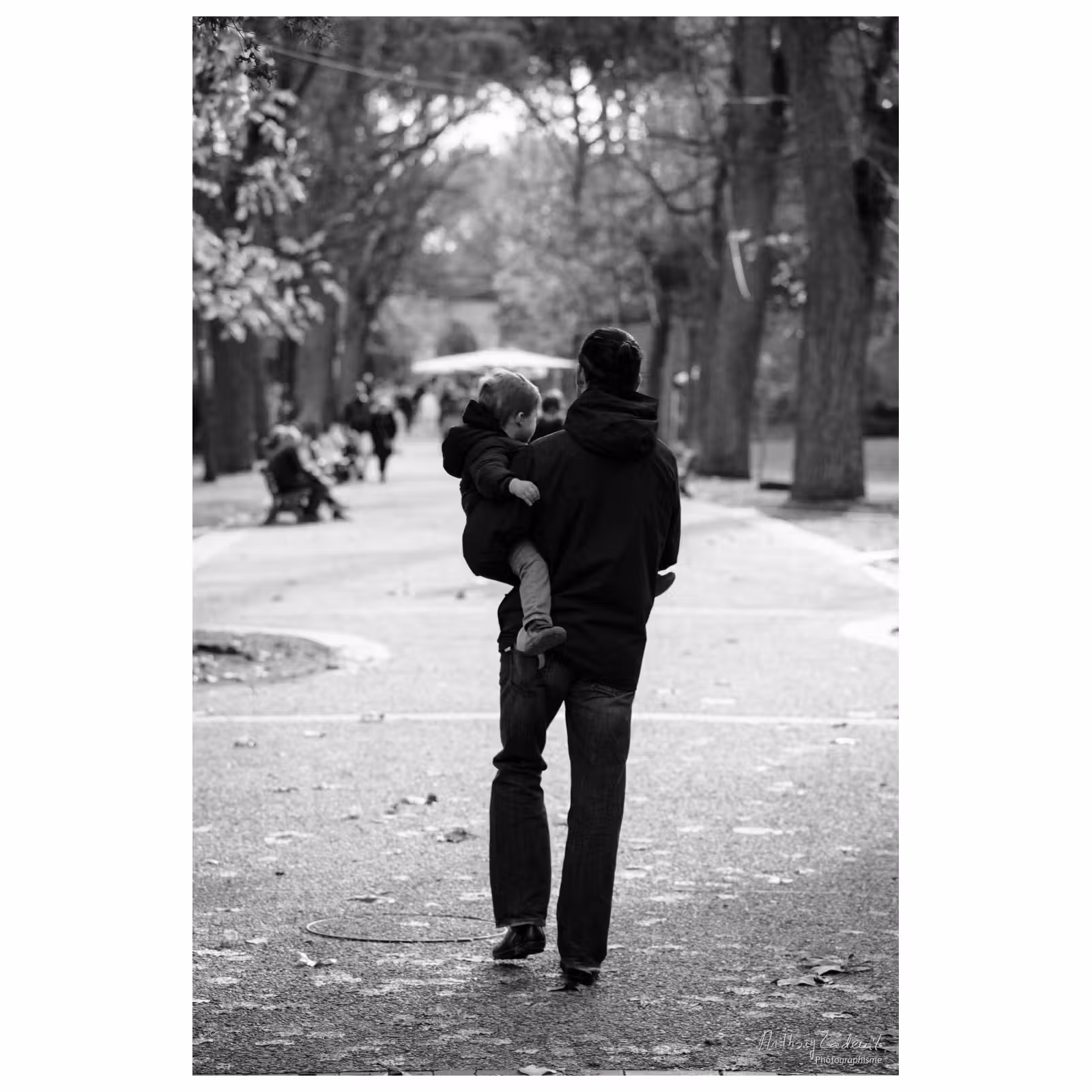 photographie d'un homme portant son enfant dans les bras