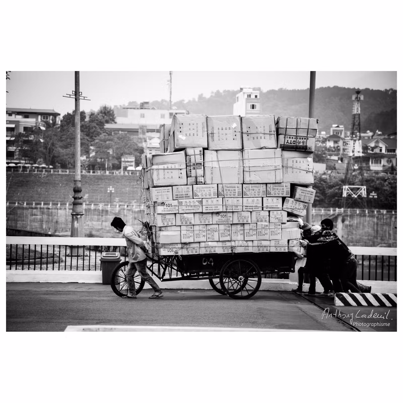 personnes poussant une charrette chargée de nombreux cartons