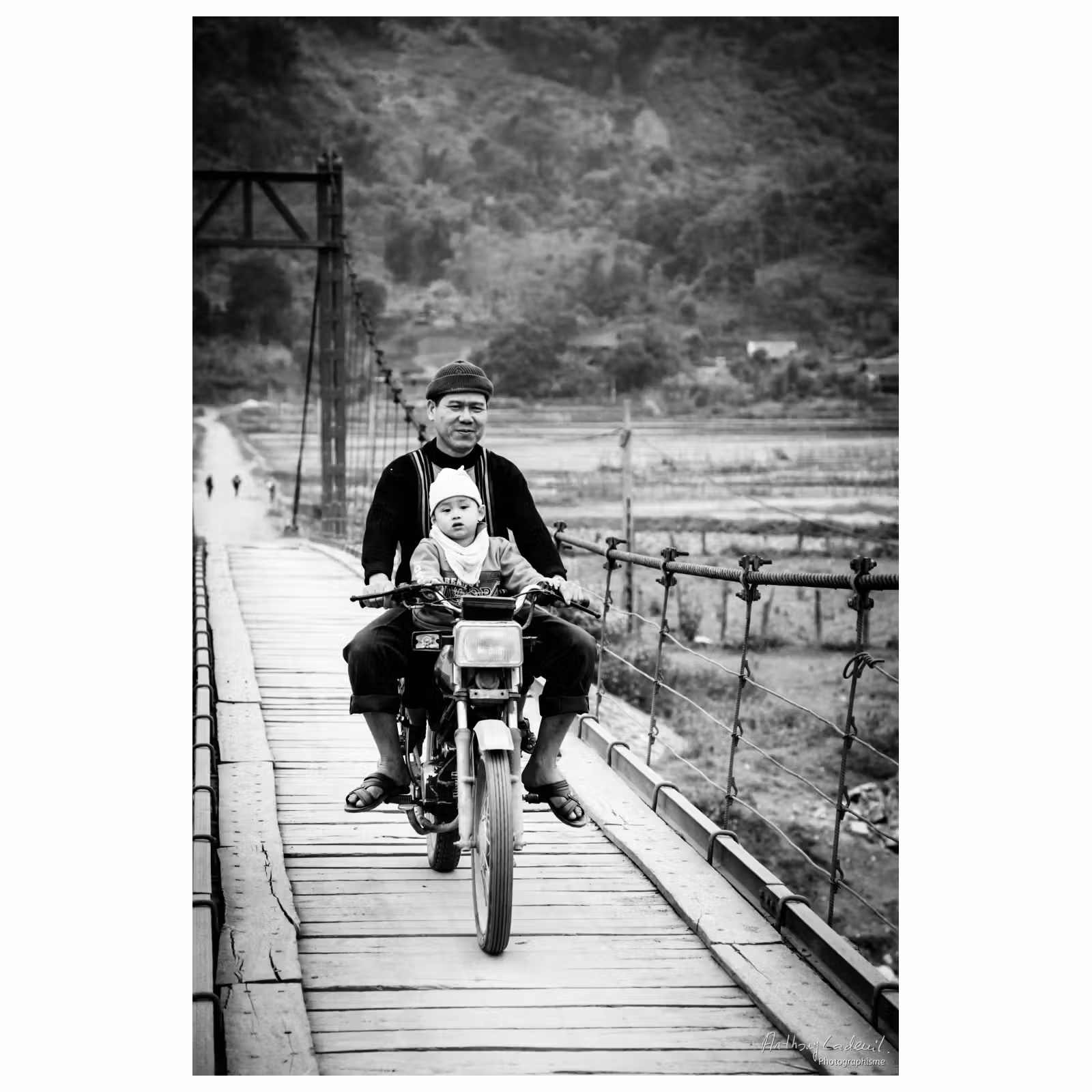 jeune enfant assis devant un homme sur une moto au vietnam