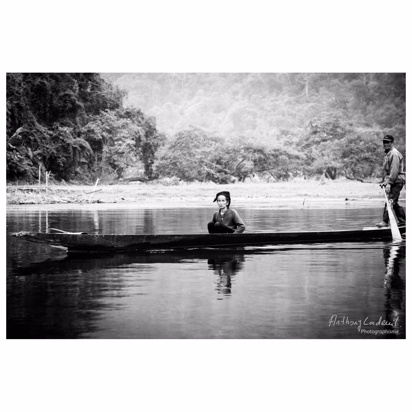 femme vietnamienne assise dans une longue barque sur l'eau